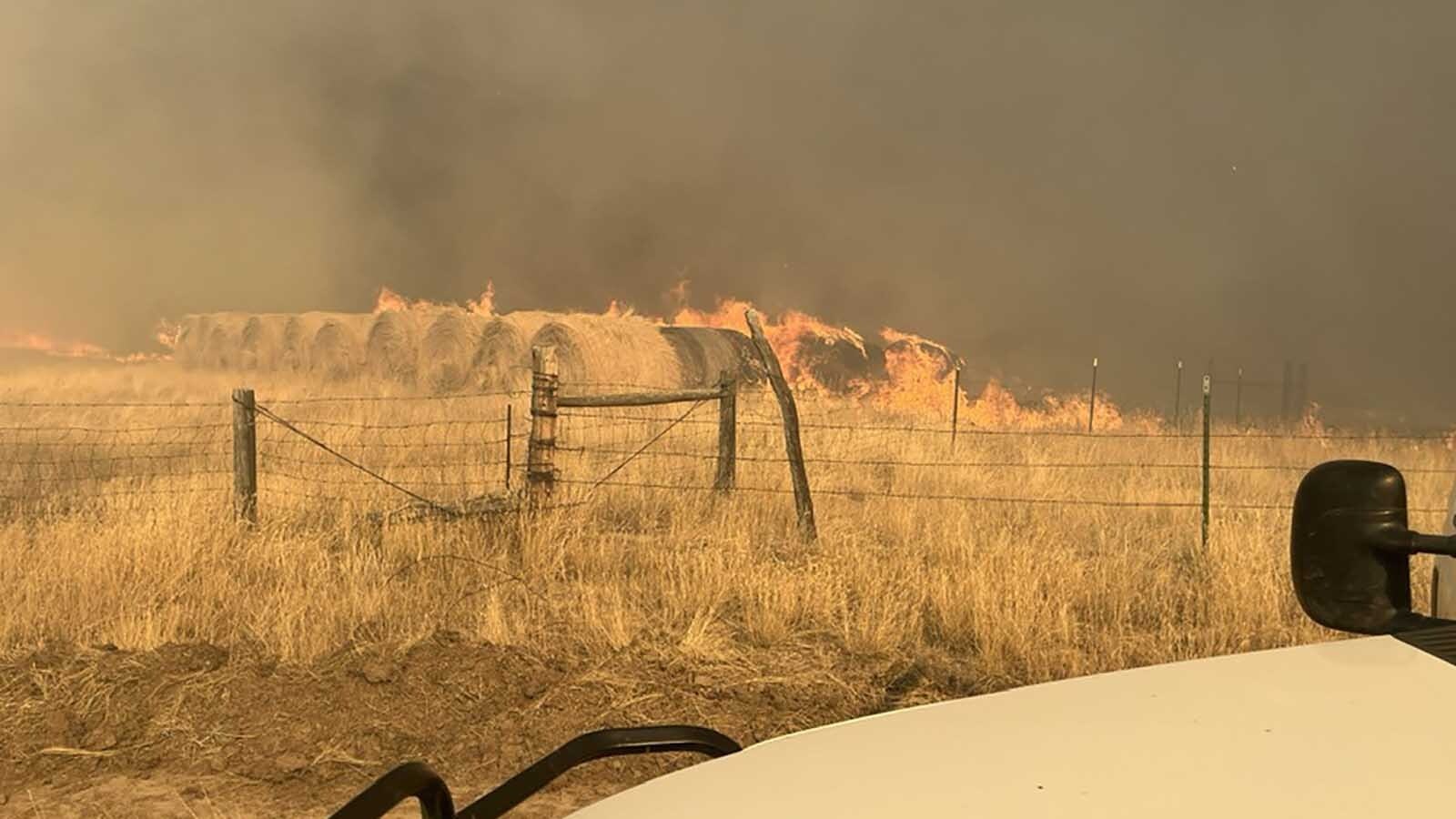 A field holding hay bales burns as the Short Draw Fire rages out of control in northern Wyoming and southern Montana.