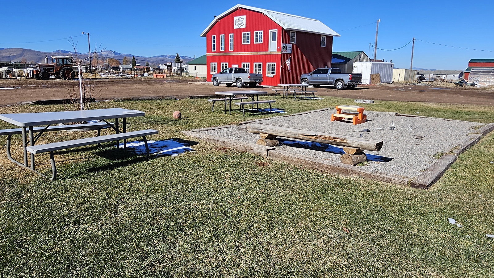 A sandbox play area at Shumway Farms, with the retail store in the background.