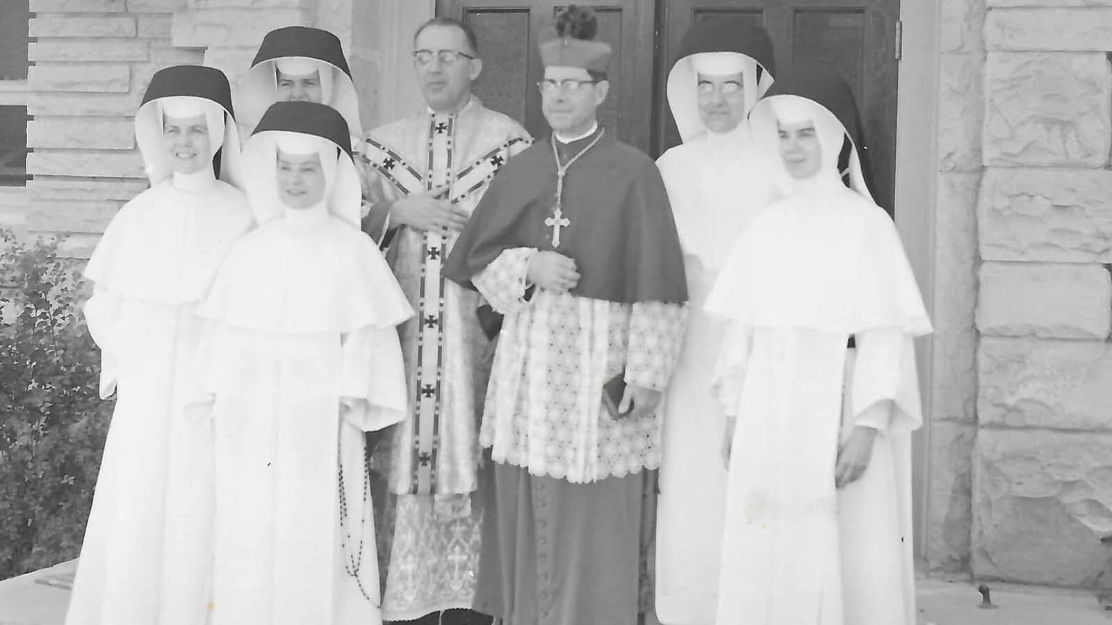 Sister Bernice, Sister Laurina, Sister Miriam Francis, far left, Monsieur Philip Krass, Bishop Newell, Sister Mary Norina and Sister Margaret,. 1955, in front of the St. Francis Church during the Silver Jubilee of the church in the Big Horn Basin.