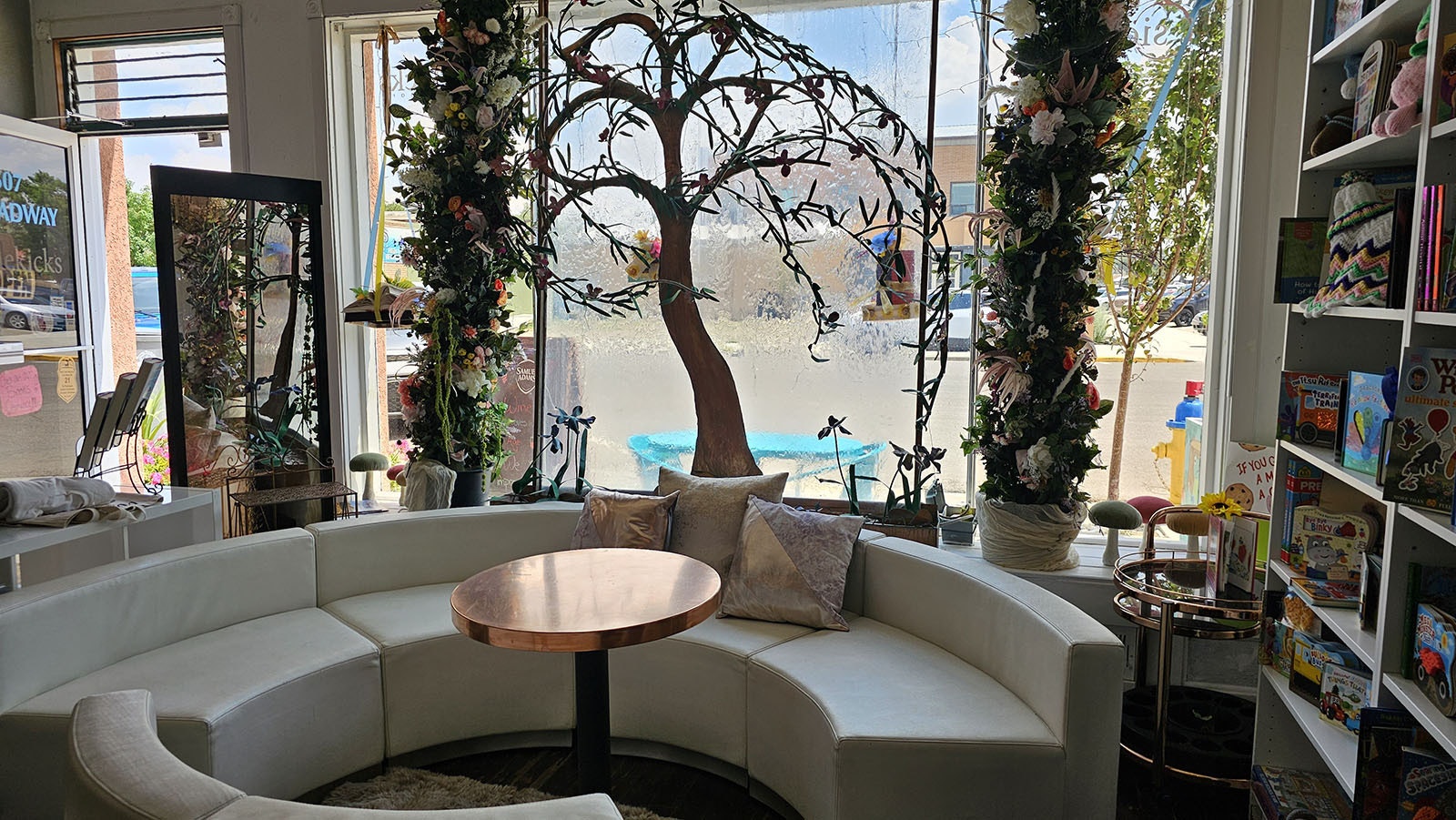 This tree with a waterfall behind it blurs the background of the street and lends an ethereal, otherworldly effect to Sidekicks Book-Bar in Rocks Springs. The round couch seating is perfect to further the effect that guests have entered a new and relaxing dimension.