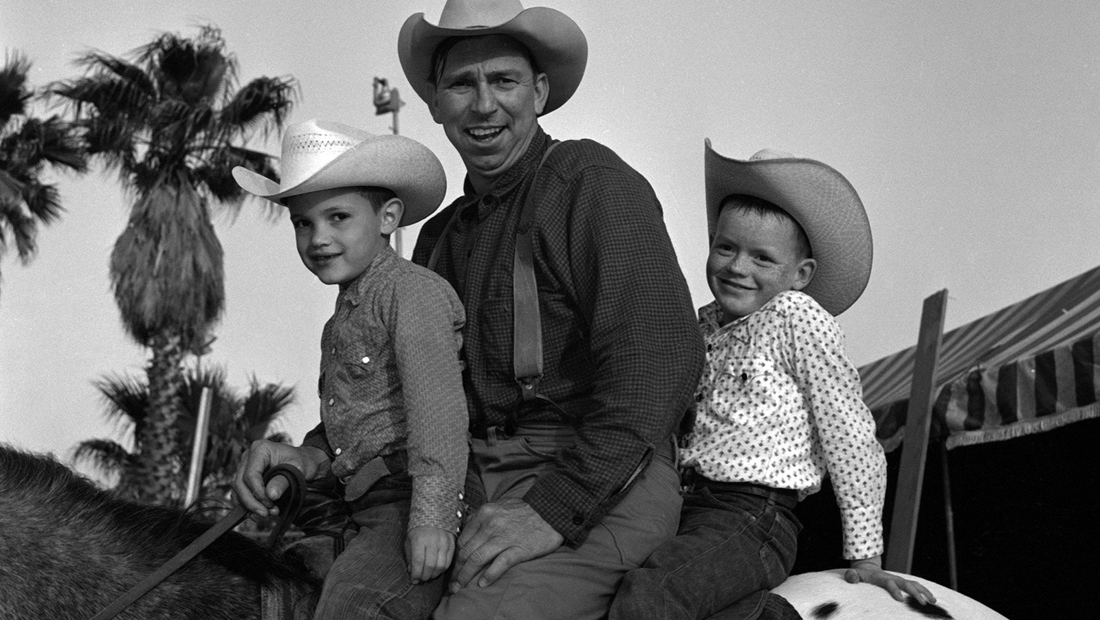 American actor Slim Pickens (born Louis Lindley, 1919-1983) as he sits, along with two unidentified boys, on an Appaloosa horse in the 1950s.