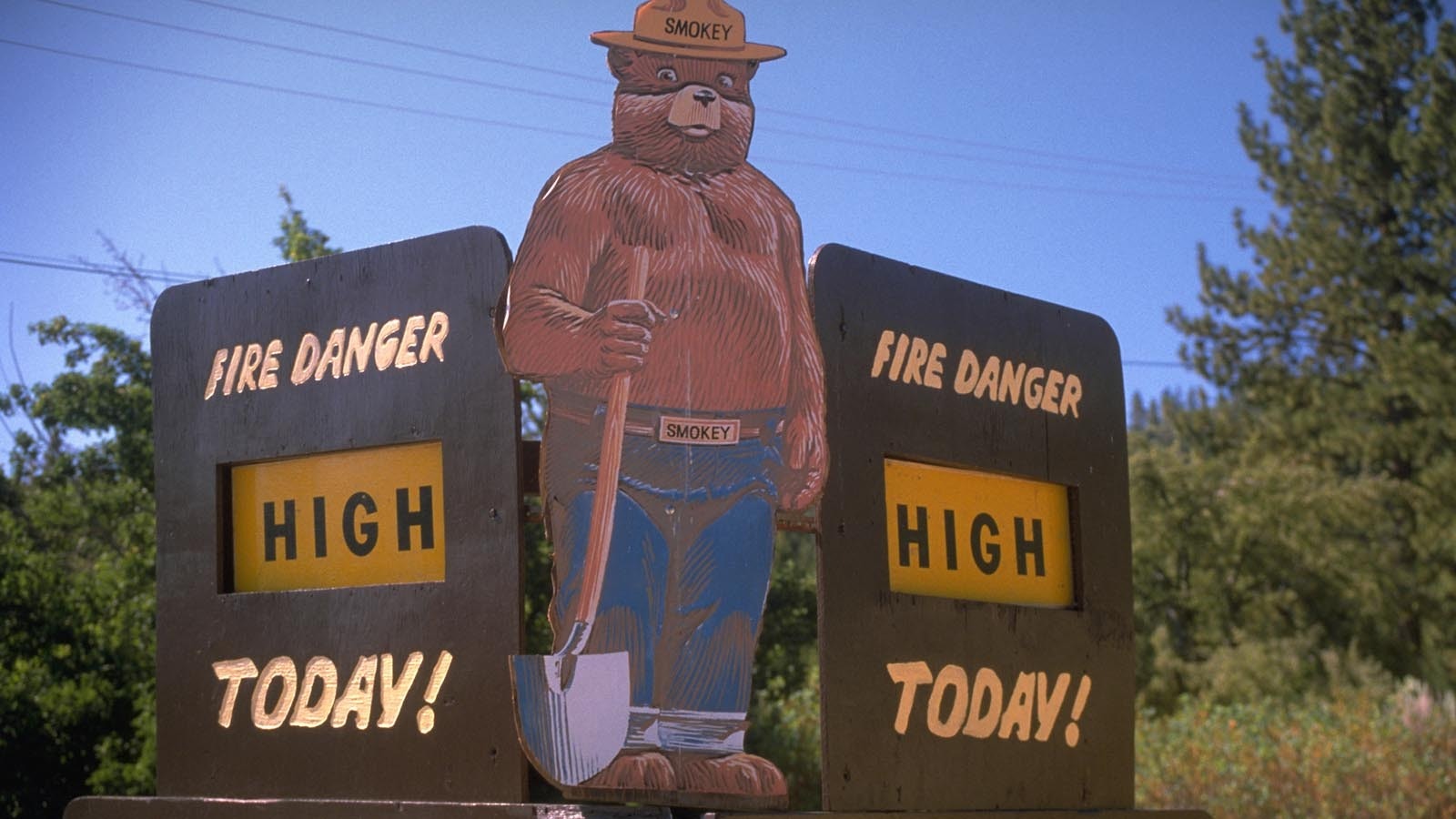 A sign depicting Smokey Bear indicates the level of fire danger in a forrest area in 1984.