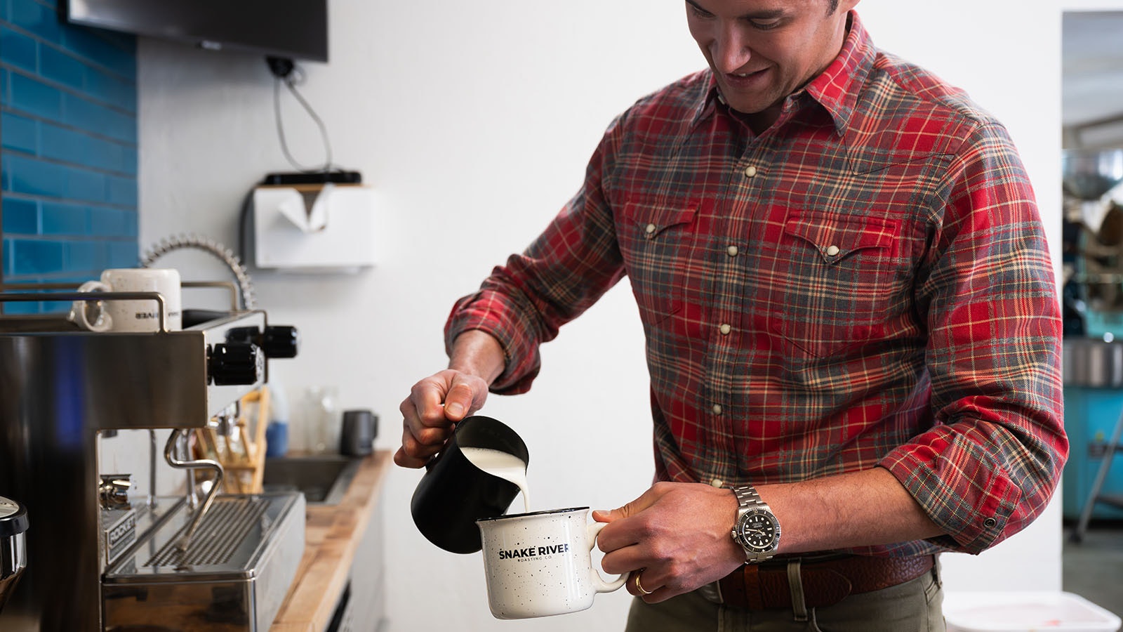 Snake River Roasting Co. owner Mekki Jaidi pours milk in a cup of coffee.