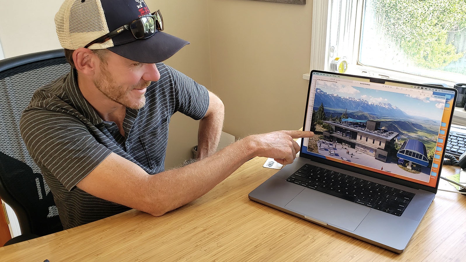 Snow King Mountain Resort President and CEO Ryan Stanley points at a computer rendering of what the new mountaintop restaurant they're building on Snow King will look like.
