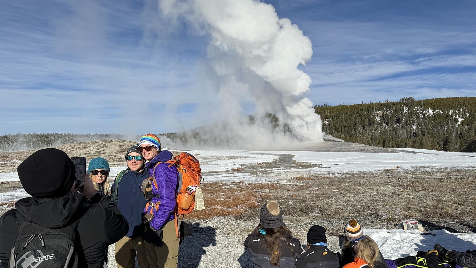 Taking pictures of an Old Faithful eruption during a mid-December snowcoach tour of Yellowstone National Park.