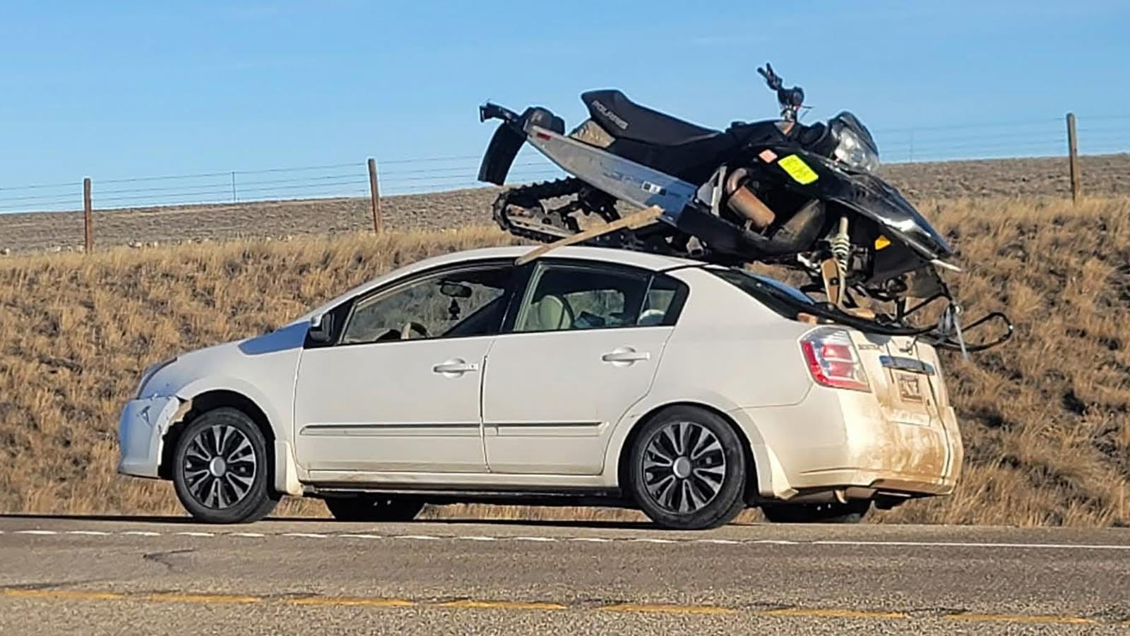 Wyoming drivers gawked at a snowmobile strapped to the a broken-down Nissan Altima on Highway 26 near Casper over the weekend. The jerry-rigged setup failed and a friend's truck came to haul both the car and snowmobile away.