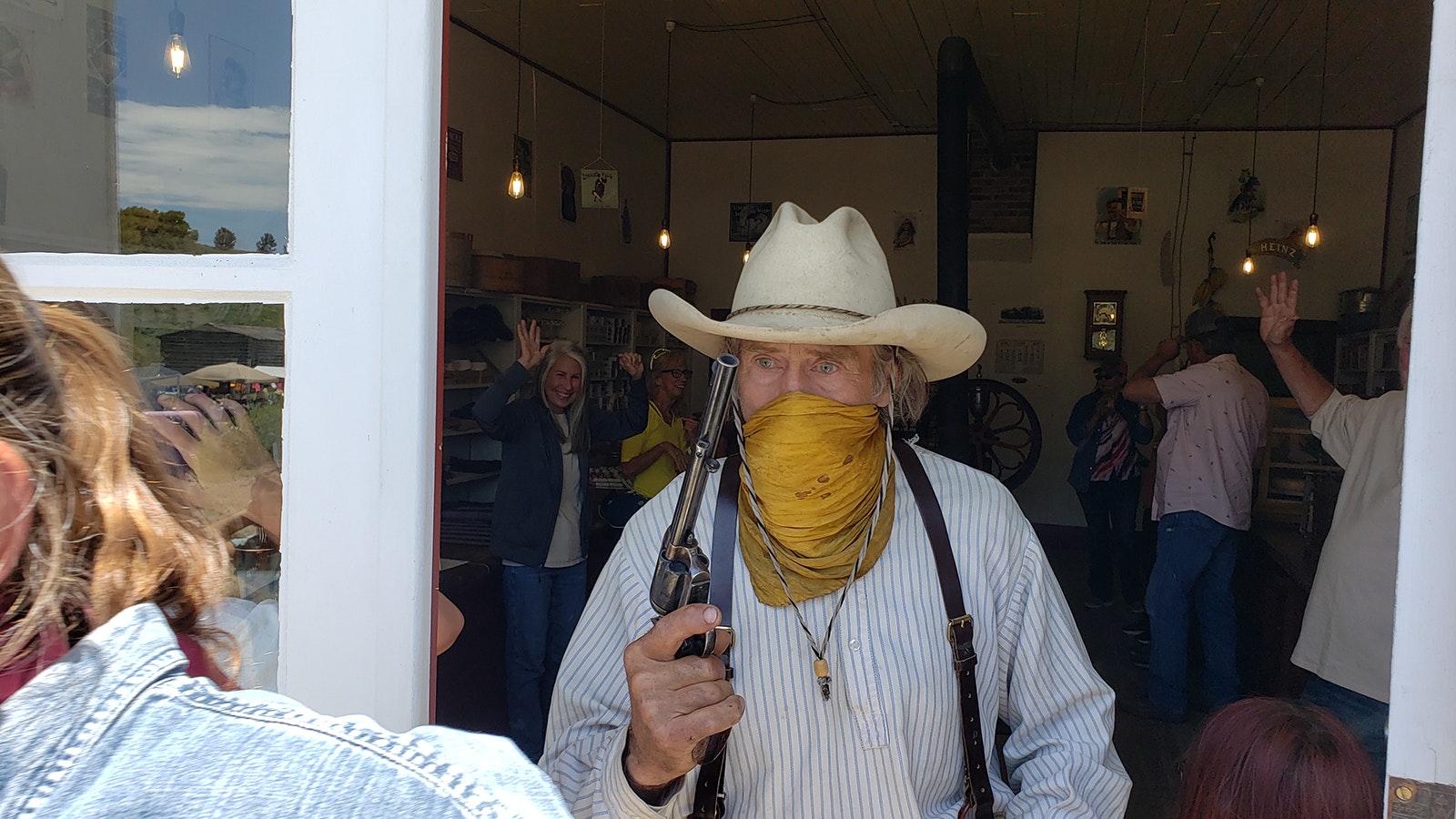 One of the bandits guards the door to keep the crowd away while another demands all the merchants money during Gold Rush Days at South Pass City.