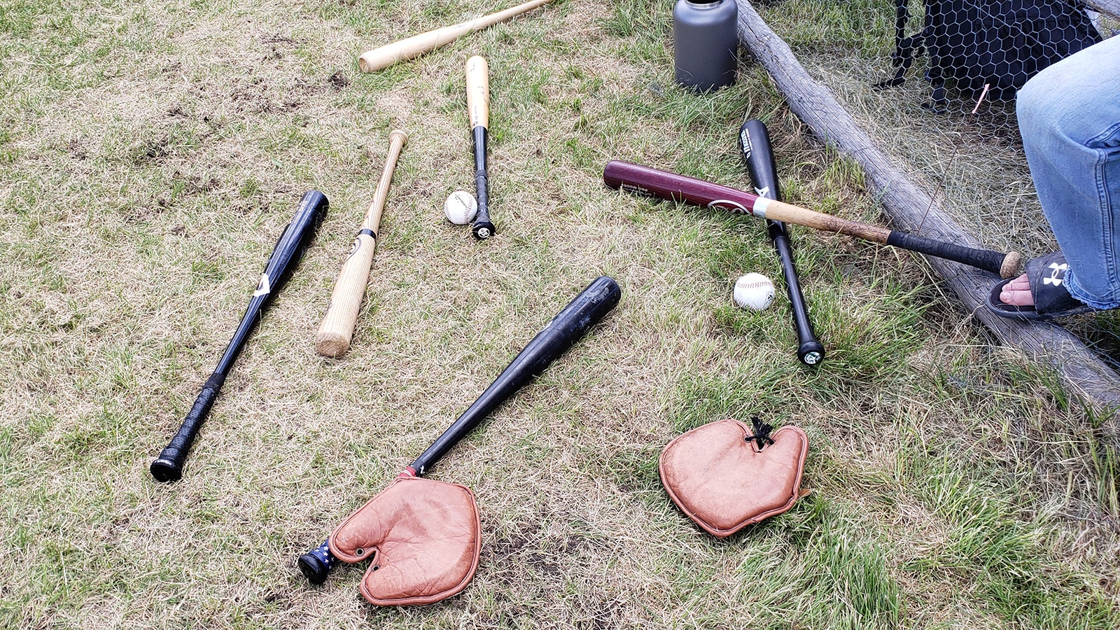 Vintage baseball gloves and bats on the ground during a game at South Pass City.