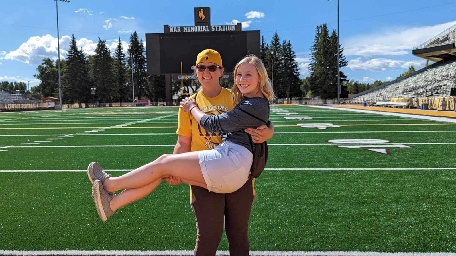 Brindi Brittain holds Adrian Wood as they get a private tour of the University of Wyoming athletics facility after presenting to P.E. teachers in Laramie.