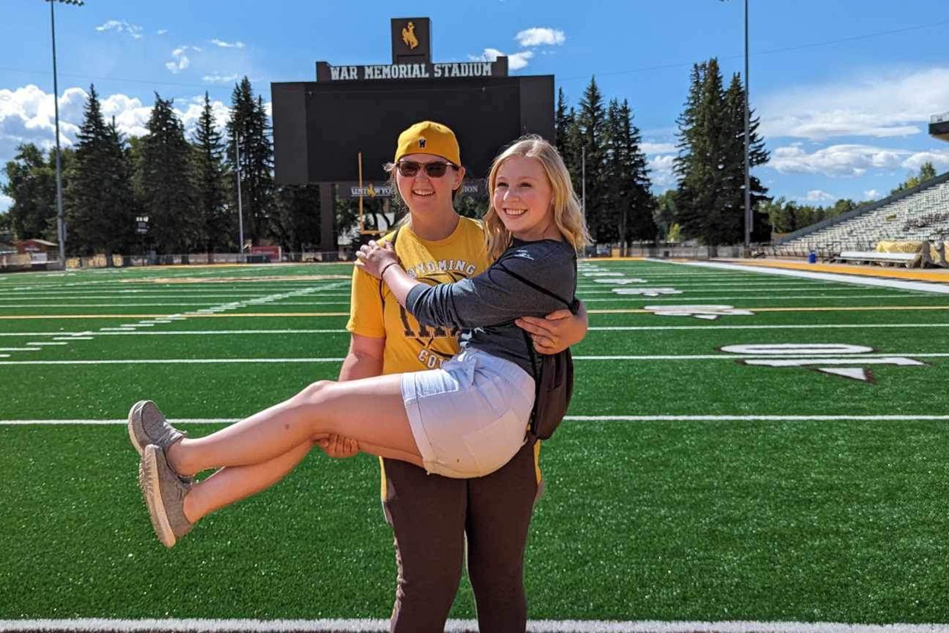 Brindi Brittain holds Adrian Wood as they get a private tour of the University of Wyoming athletics facility after presenting to P.E. teachers in Laramie.