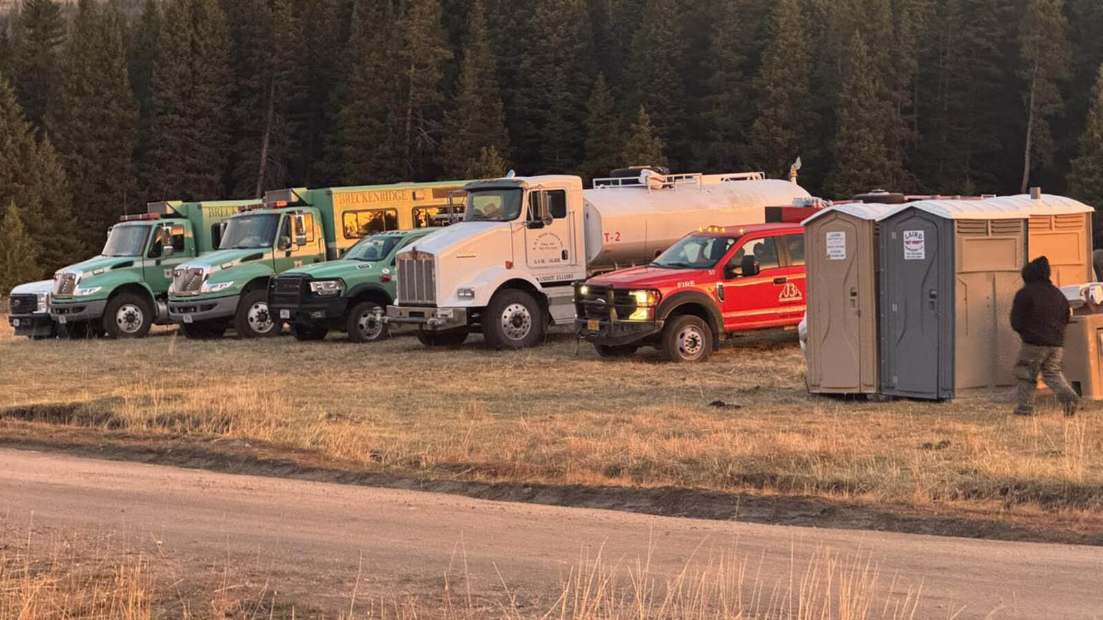 Hotshot trucks lined up in a row next to a fuel truck.