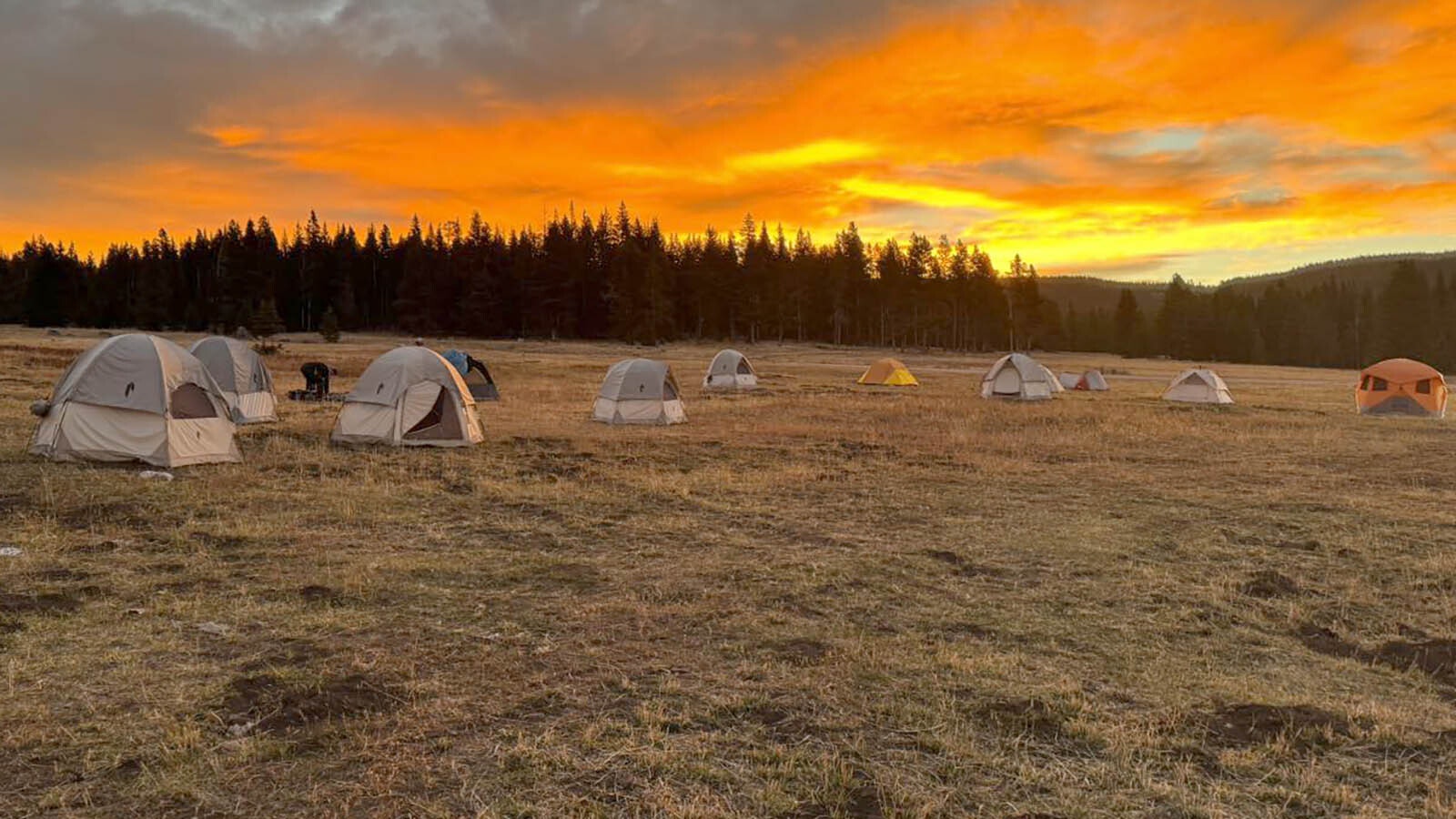 The sun sets over a collection of tents set up at Antelope Butte.