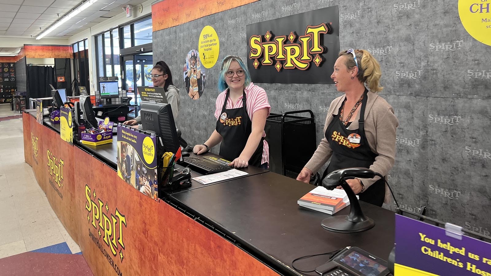 Spirit Halloween store manager Jennifer Turpin, right, along with employees Taylor Turpin and Alexandria Romero wait for customers to start pouring into the store, which opened late Thursday morning.