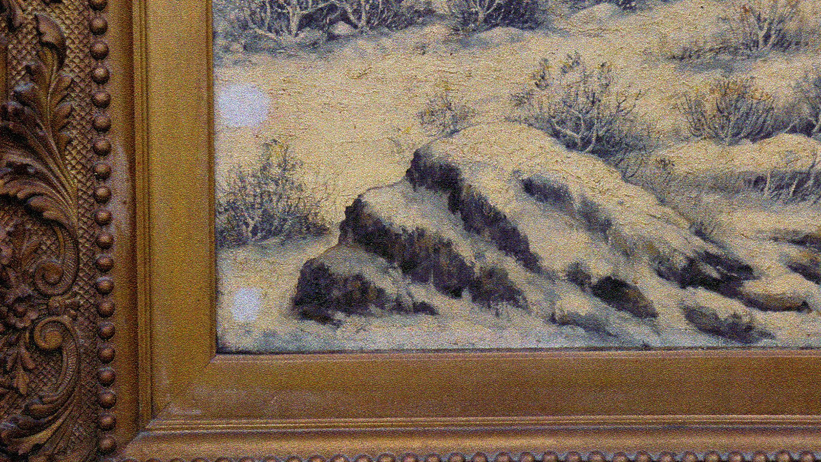 Close-up photo of the large painting titled "Shoshone Canyon," she shows the white snow stained and discolored from decades of oil, smoke and other contaminants gathered from hanging in a restaurant.