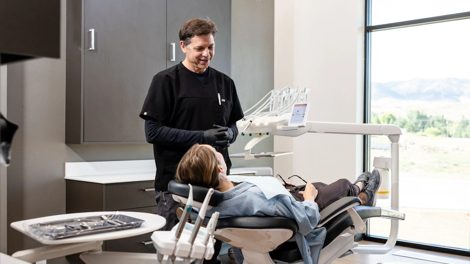Legacy Institute Dental's Dr. Stuart Youmans speaking with a patient about dental implants.