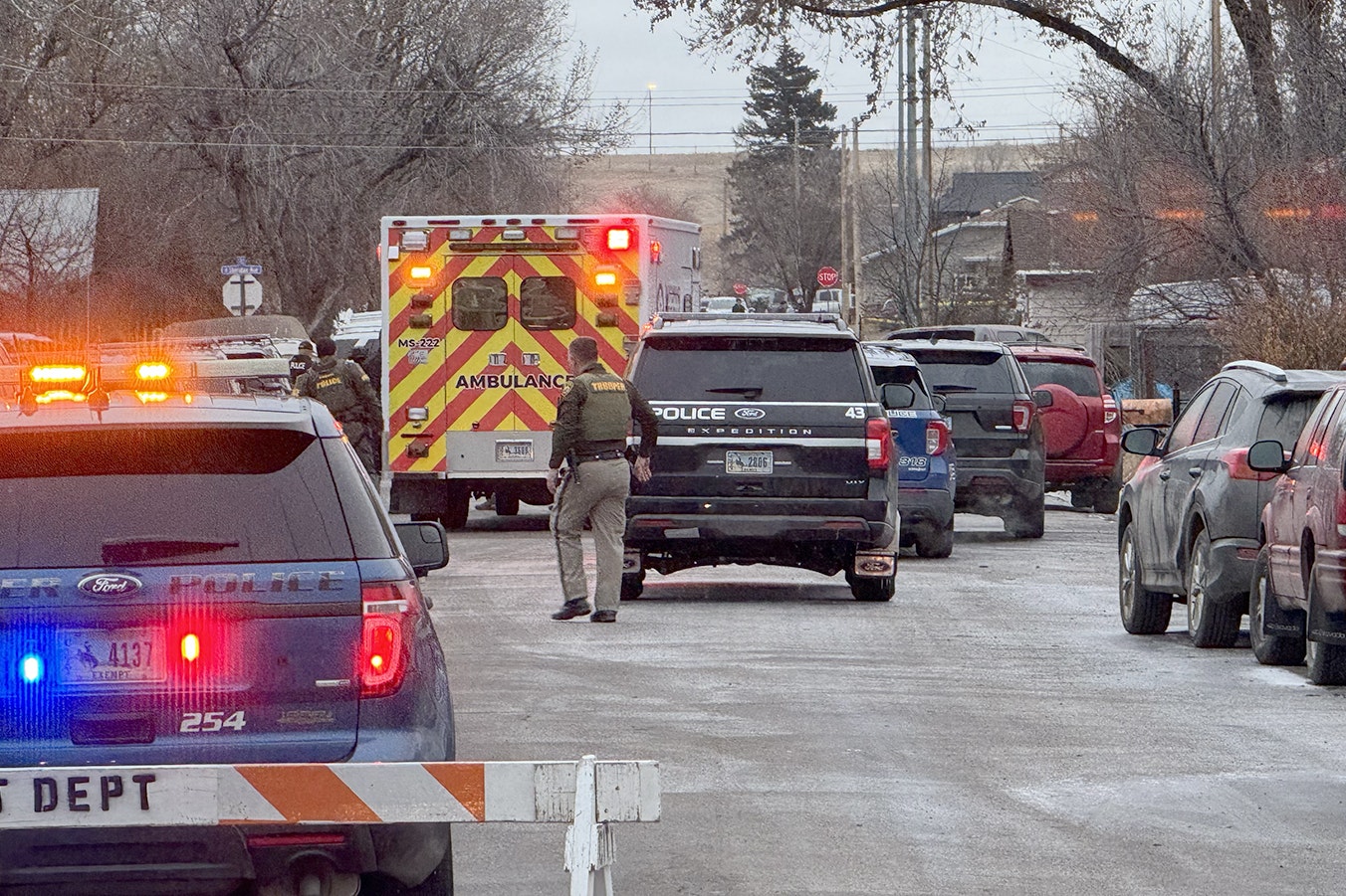 An ambulance pulls up to the house where an armed suspect was barricaded for more than 30 hours after a Sheridan police officer was shot and killed Tuesday.