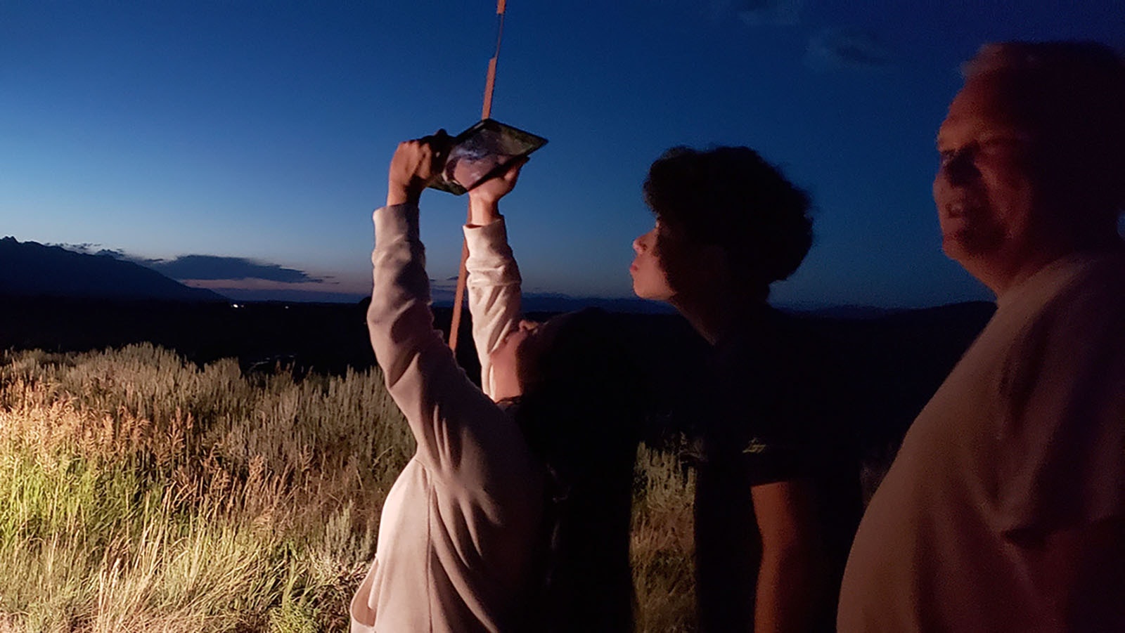 A tour group from Texas tries out an iPad equipped with an app that will highlight anything interesting in the piece of sky its being pointed at.