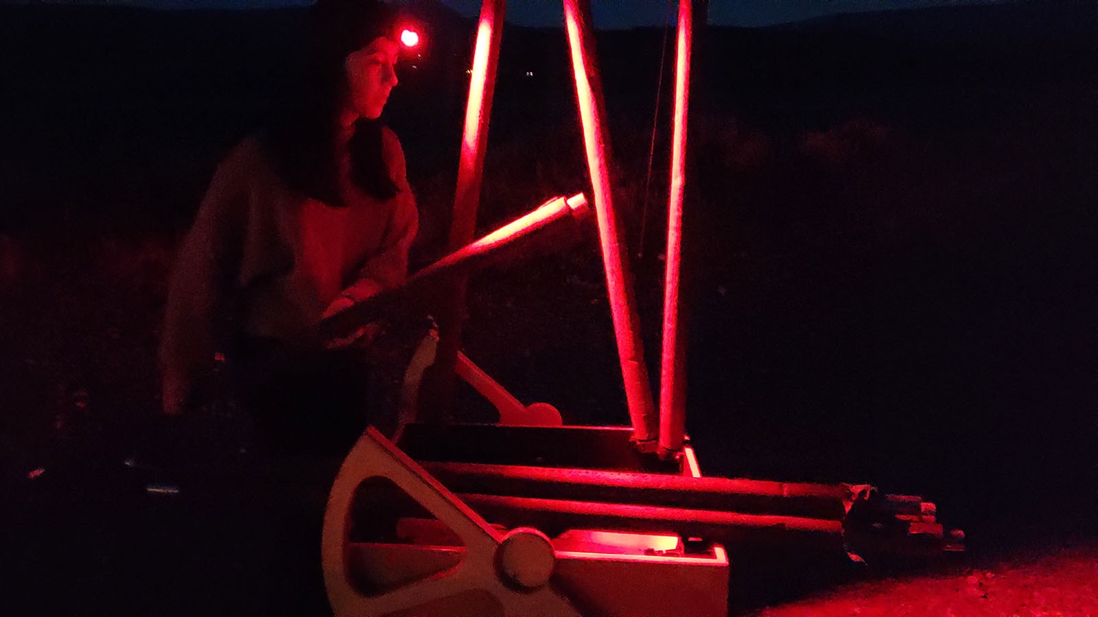Rachel Fischer puts together a mobile telescope on the fringe of Grand Teton National Park using only a red light. Red lights don't cause one's eyes to contract, helping to preserve better night sight.