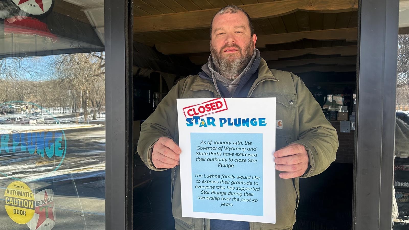 Shawn Norby holds a sign explaining the Star Plunge water park and hot springs in Thermopolis was closed Tuesday, a day earlier than expected as a dispute continues between the state and the facility's owners/operators.