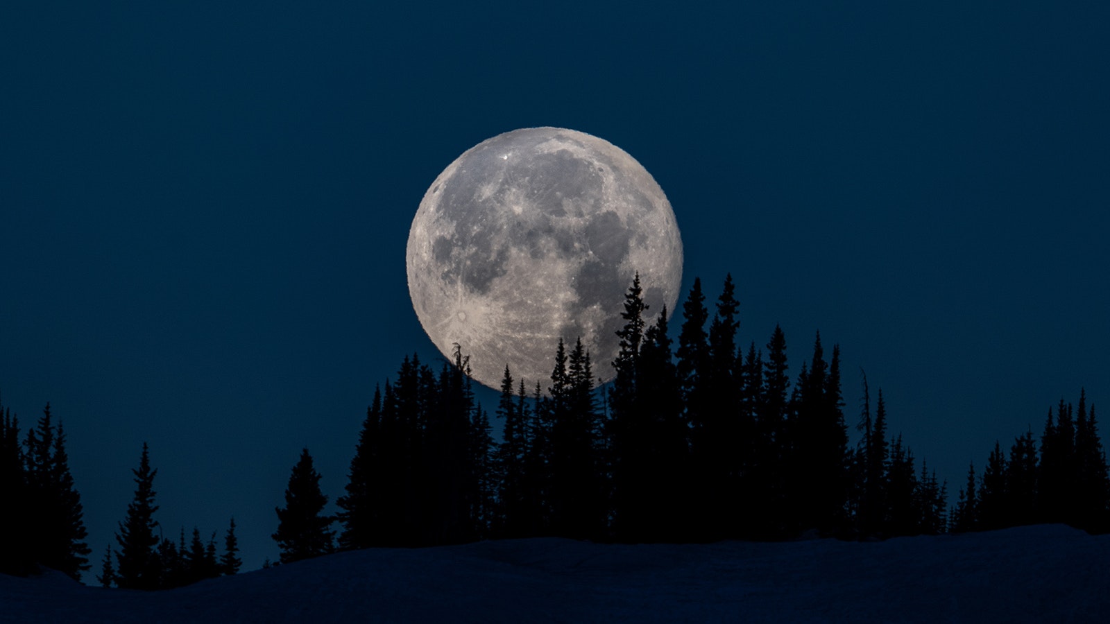 Chris Mickey, an avid camper and night sky photographer, recently got this shot of a strawberry moon setting over the Snowy Range Mountains.