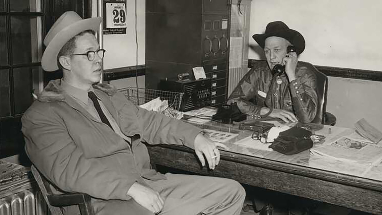 Natrona County Deputy Sheriff Bill Romer, left, sits in a chair as Converse County Sheriff Earl Heflin talks on the phone. Romer happened upon the murder scene on the highway between Douglas and Glenrock.