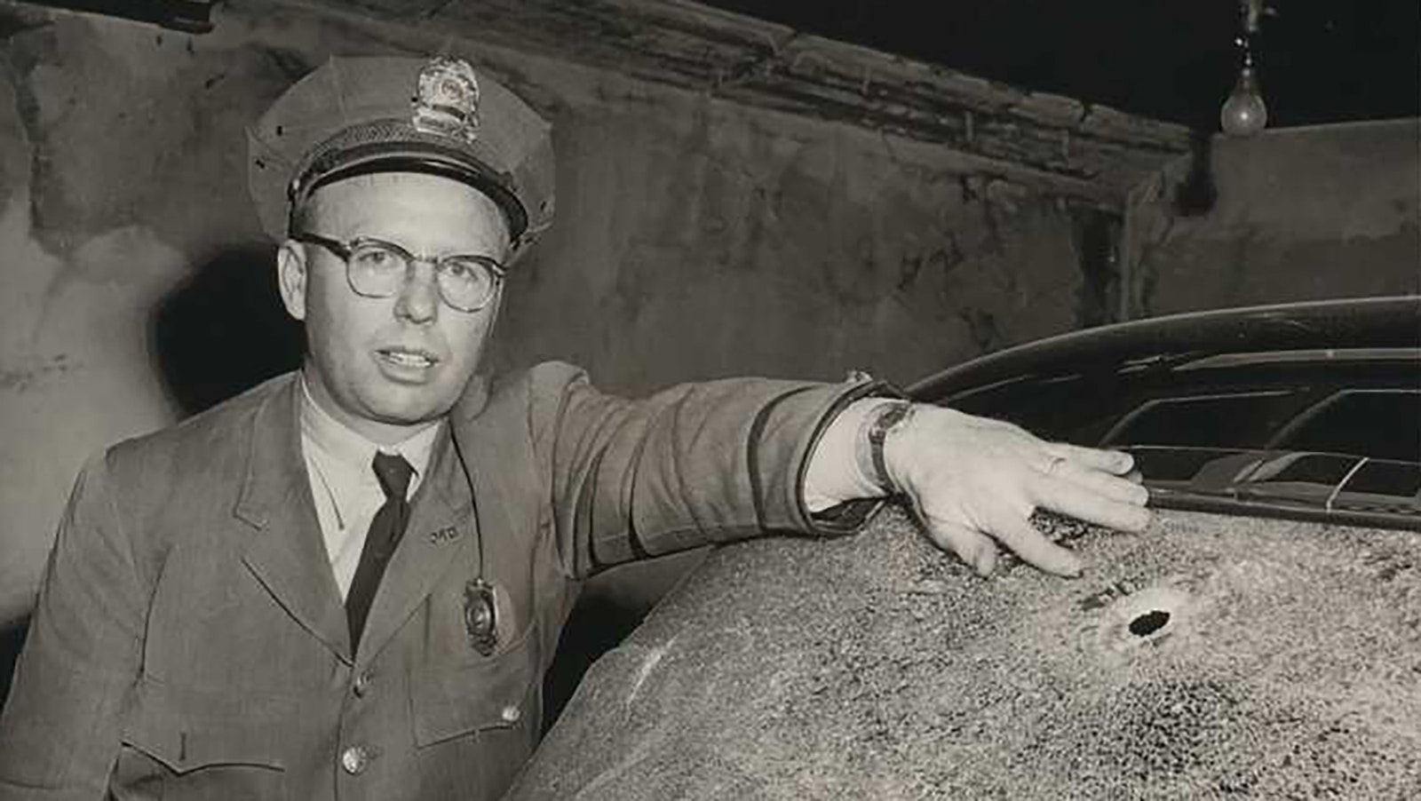 Douglas Police Chief Robert Ainslie points to one of two bullet holes in the back of the stolen Packard.