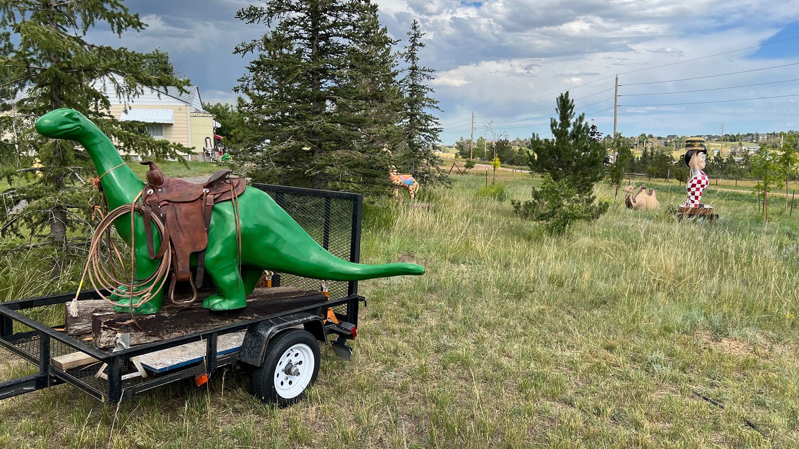 A truly Wyomingized Sinclair dinosaur, with a giraffe, camel and Big Boy in the background.