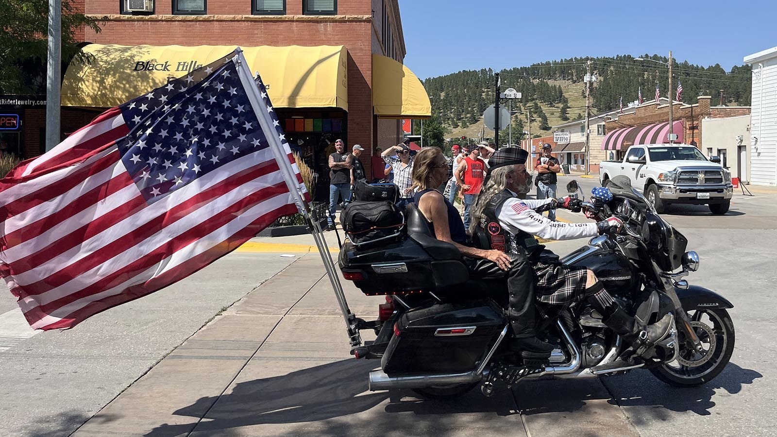 A motorcycle passes spectators on Main Street during the 84th Sturgis Motorcycle Rally’s opening ceremony and parade.