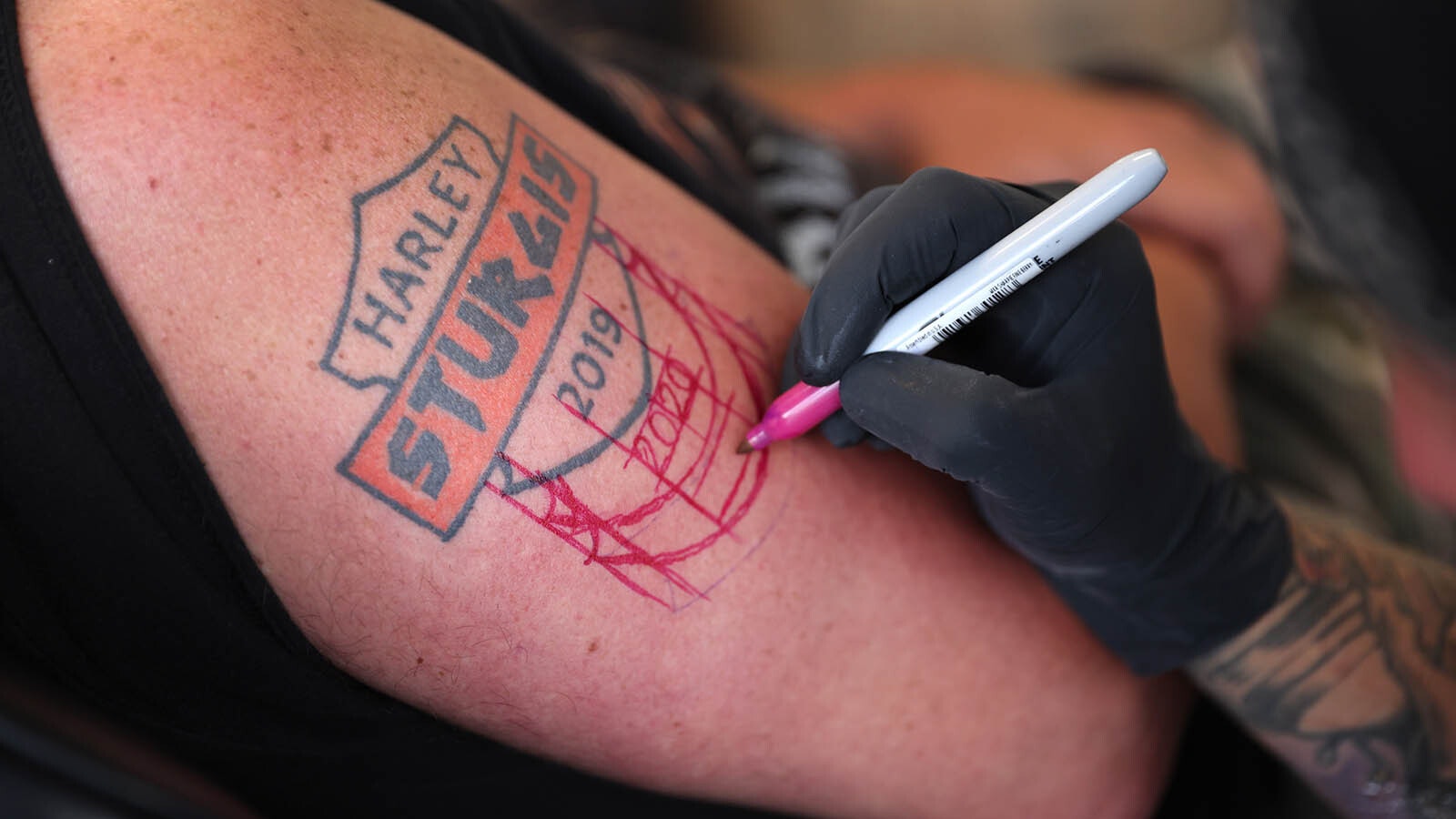 Al Nelsen of Kelsey, Washington, gets his Sturgis tattoo updated by Tim Martin at Fat Cats Tattoos during the 81st annual Sturgis Motorcycle Rally in 2021.