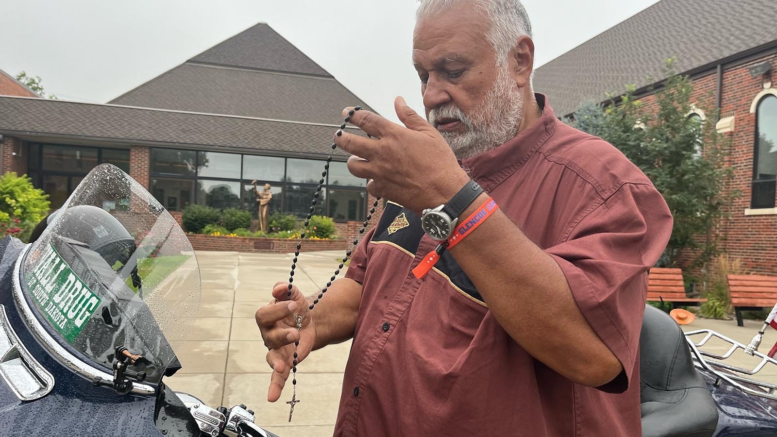 Horacio Vela stands near his Harley-Davidson after Catholic Mass on Sunday. Vela carries a rosary with him as he rides.