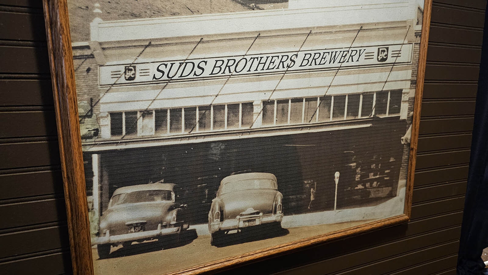 The bar's owners blew this photo up to add their name to it with photoshop. When they did, they also noticed a young girl in a white dress — which looked eerily similar to the photo of a ghost girl watching diners at the restaurant.