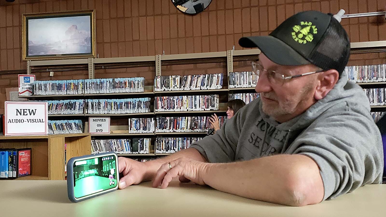 An app on this cellphone shows what appears to be a ghost child dancing or walking around in front of the library's DVD section.