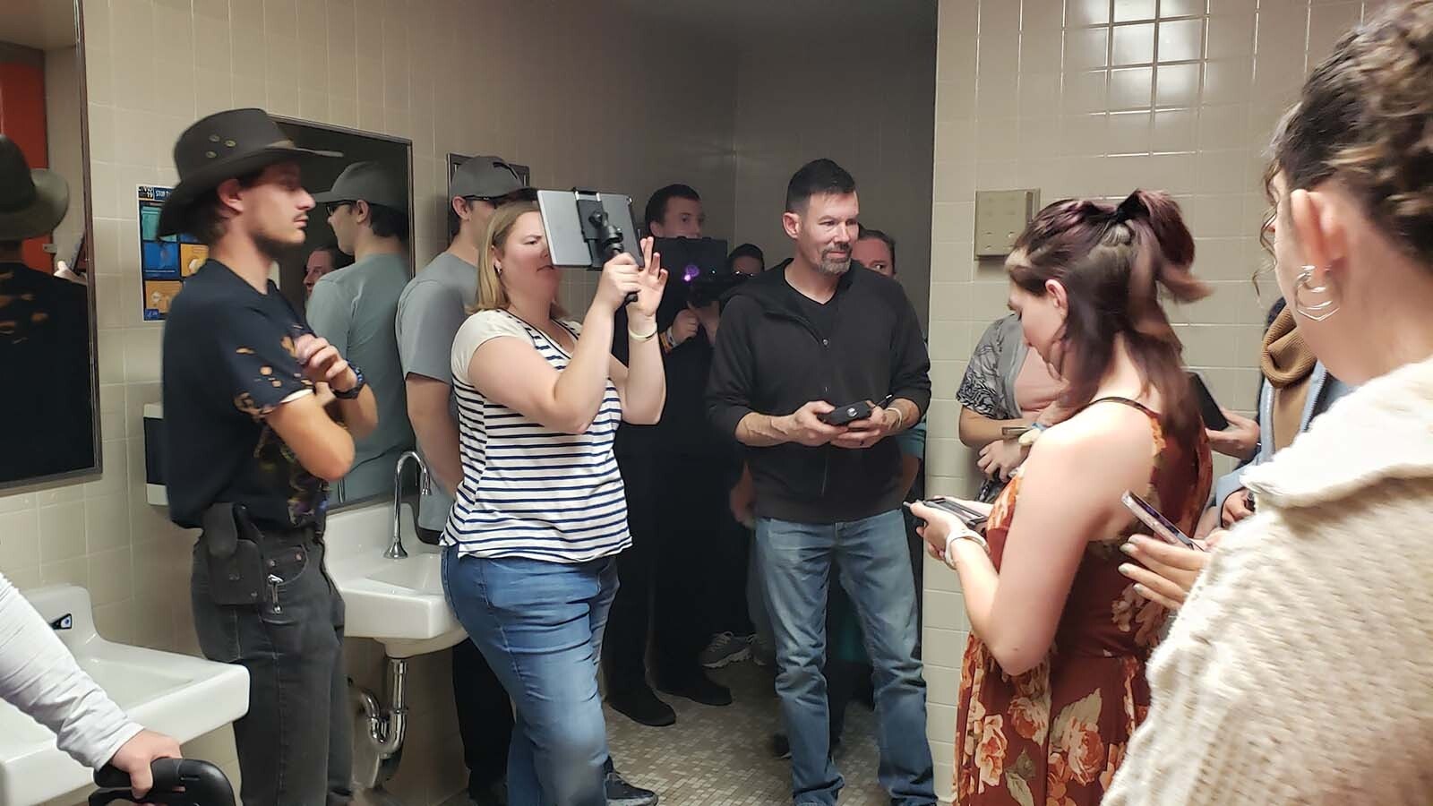 In the women's bathroom at Sweetwater County Library, ghost tour participants check spirit box apps on phones and gaze through a device that scans for electromagnetic energy.