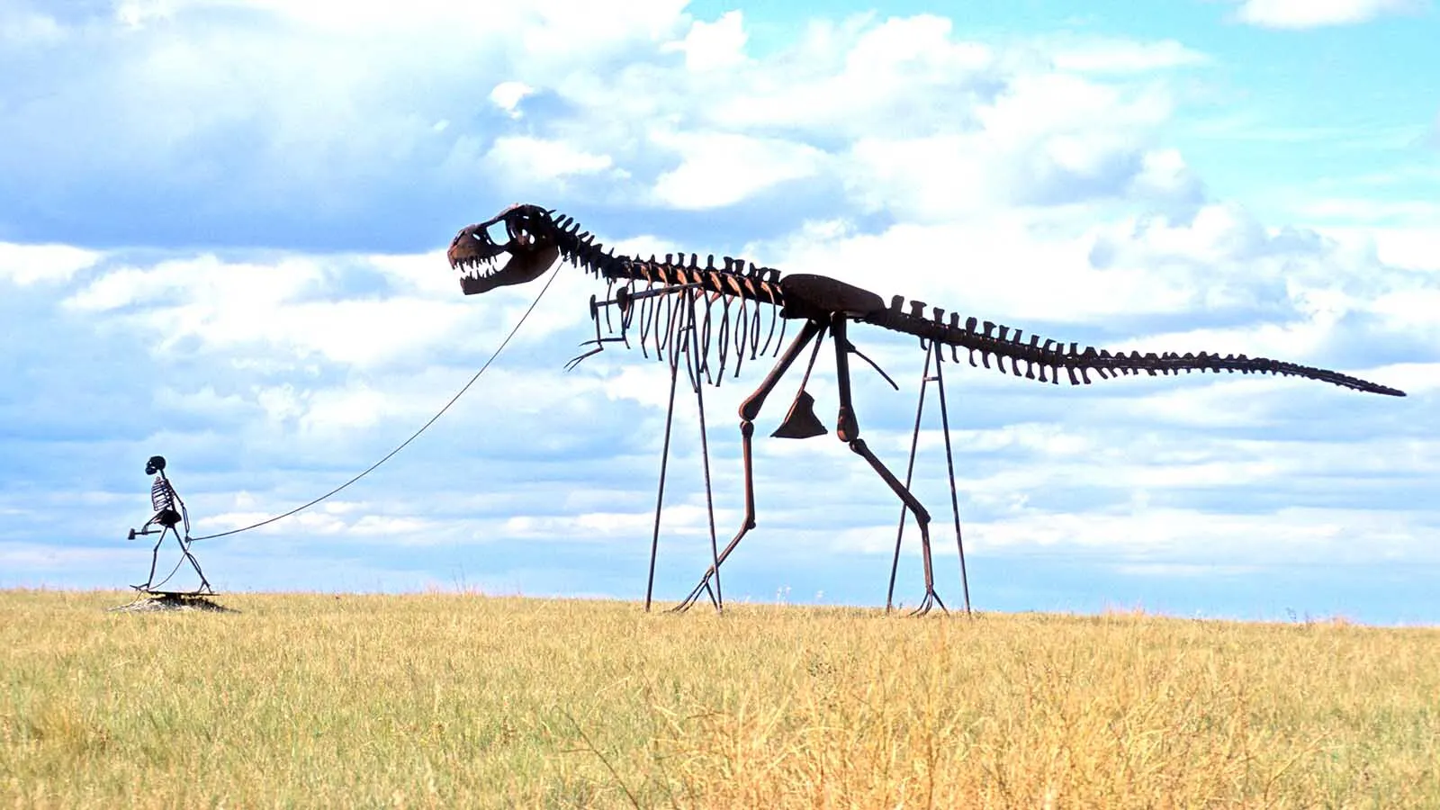 For decades, motorists speeding down Interstate 90 in west-central South Dakota have done double takes at a towering human skeleton leading a T. rex on a leash. It’s a quirky prairie creation born from one man’s lifelong dream to build his own dinosaur.