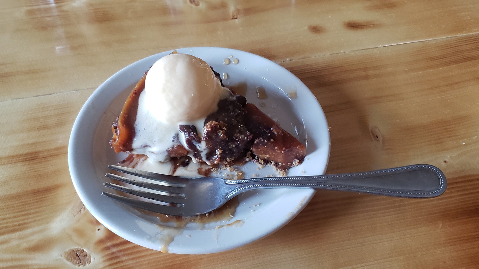 A pecan tart with ice cream served warm.