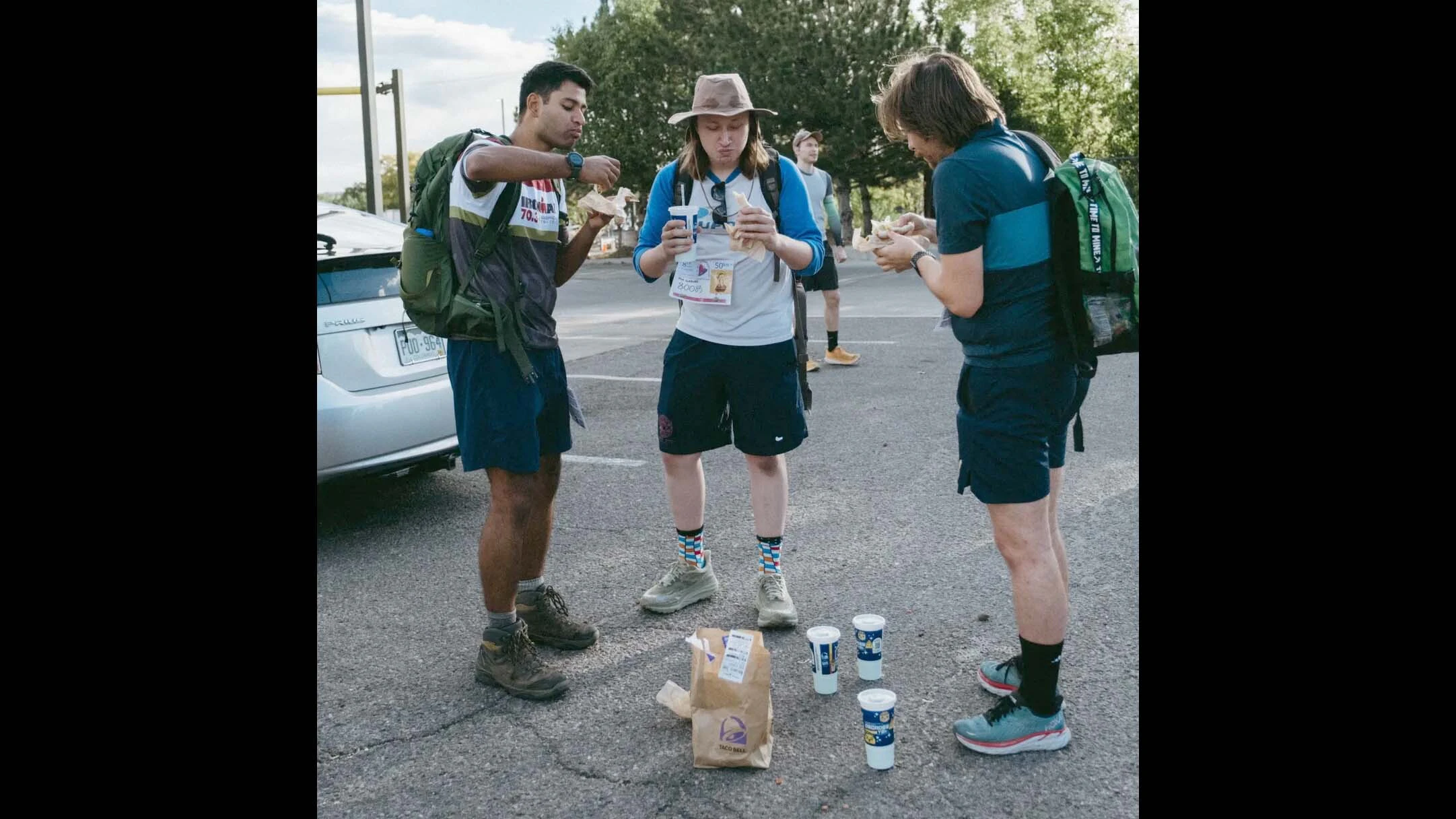 Three competitors fuel up at one of the feeding stops on the 2025 Denver Taco Bell 50K.