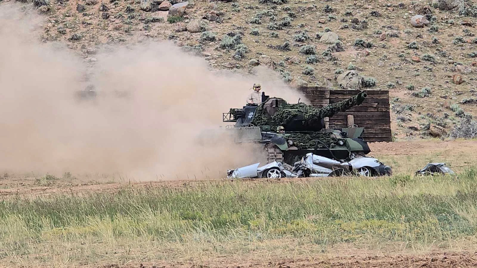 The Leopard tank is just making sure this white car is flatter than a pancake.