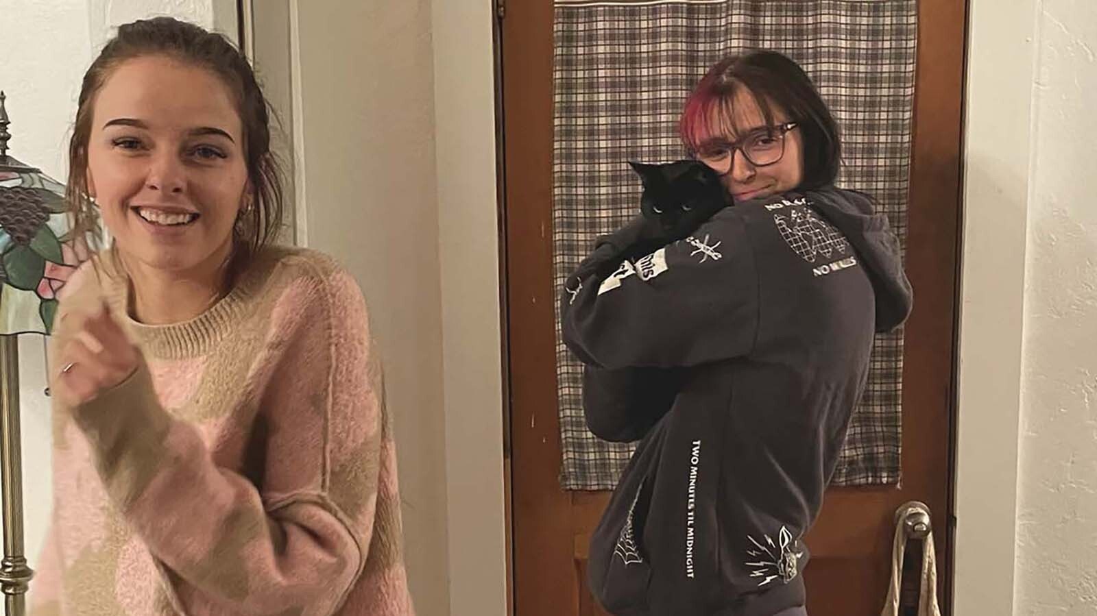 Macey Dawn Bradshaw snuggles a cat in this photo with her holder sister, Taylor Bradshaw. Macey was shot and killed by her ex-boyfriend less than three weeks ago.