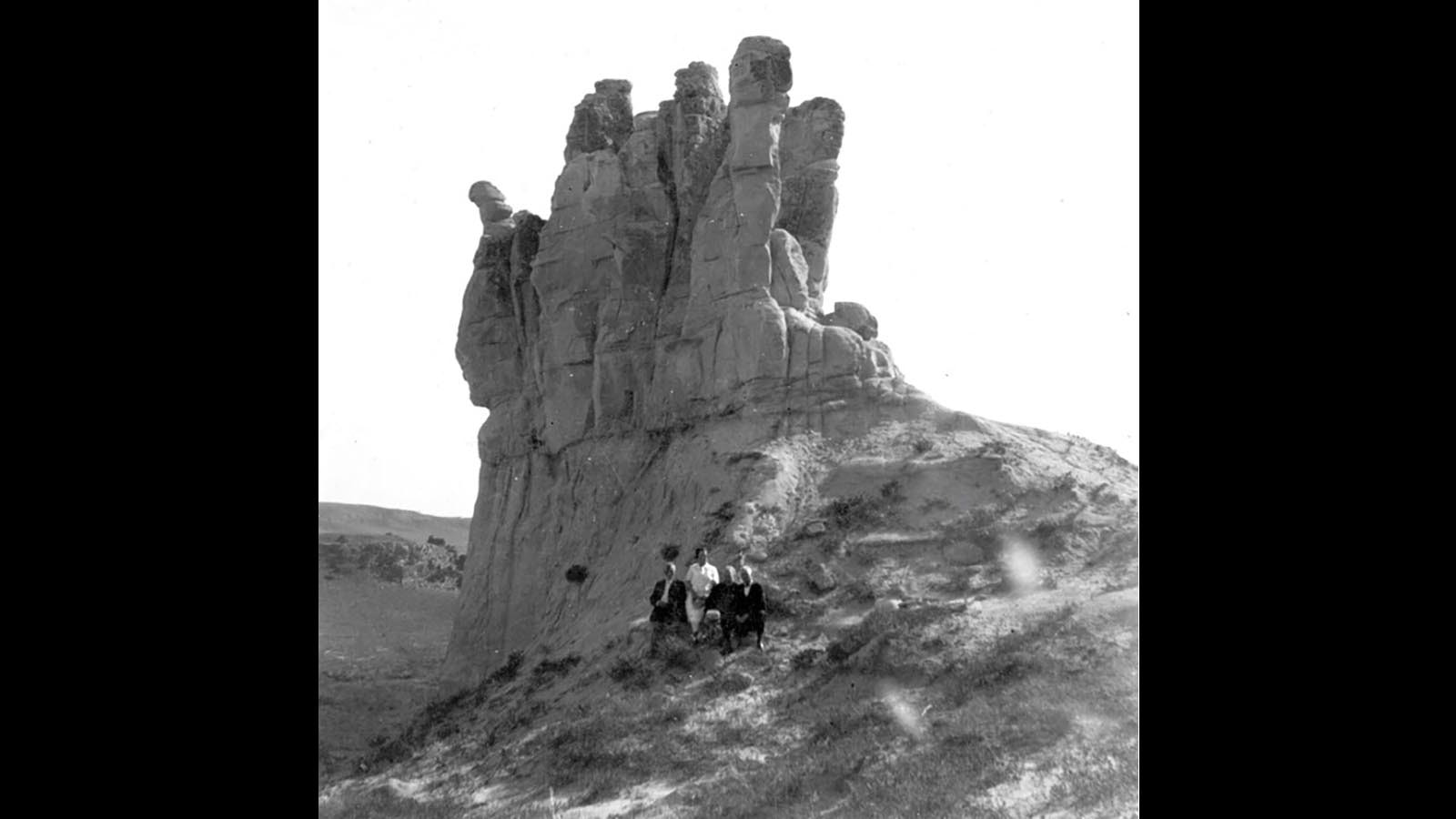 A family poses for a photo at Teapot rock, a formation for which the Teapot Dome oil and gas reserve was named. It sits about six miles west of the southern end of the 10,000-acre Teapot Naval Oil Reserve.