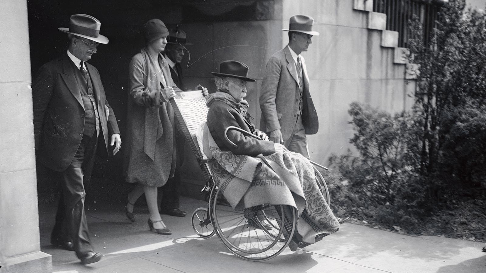 Secretary of the Interior Albert Bacon Fall being wheeled from a Washington, D.C., courtroom during the investigation into the Teapot Dome scandal in October 1929. The court found Fall guilty of bribery and conspiracy.