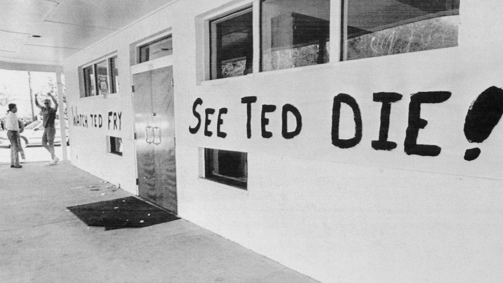 Florida State University's Chi Phi fraternity celebrates the execution of Ted Bundy with a large banner that says, "Watch Ted Fry, See Ted Die!" as they prepare for an evening cookout where they will serve "Bundy burgers" and "electrified hot dogs." Bundy attacked five women and killed two Chi Omega coeds on the campus in 1978.