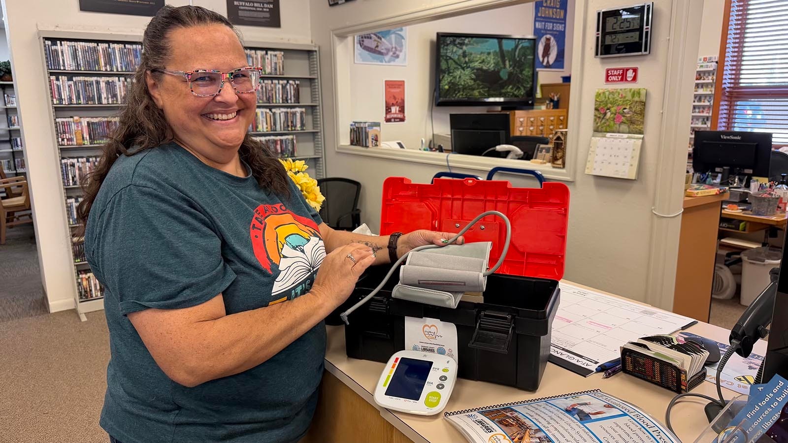 Librarian Rhonda Carter displays the blood pressure cuff that the Ten Sleep Branch Library will check out alongside books. The cuffs have gone to both locals with medical issues as well as students for their health class.
