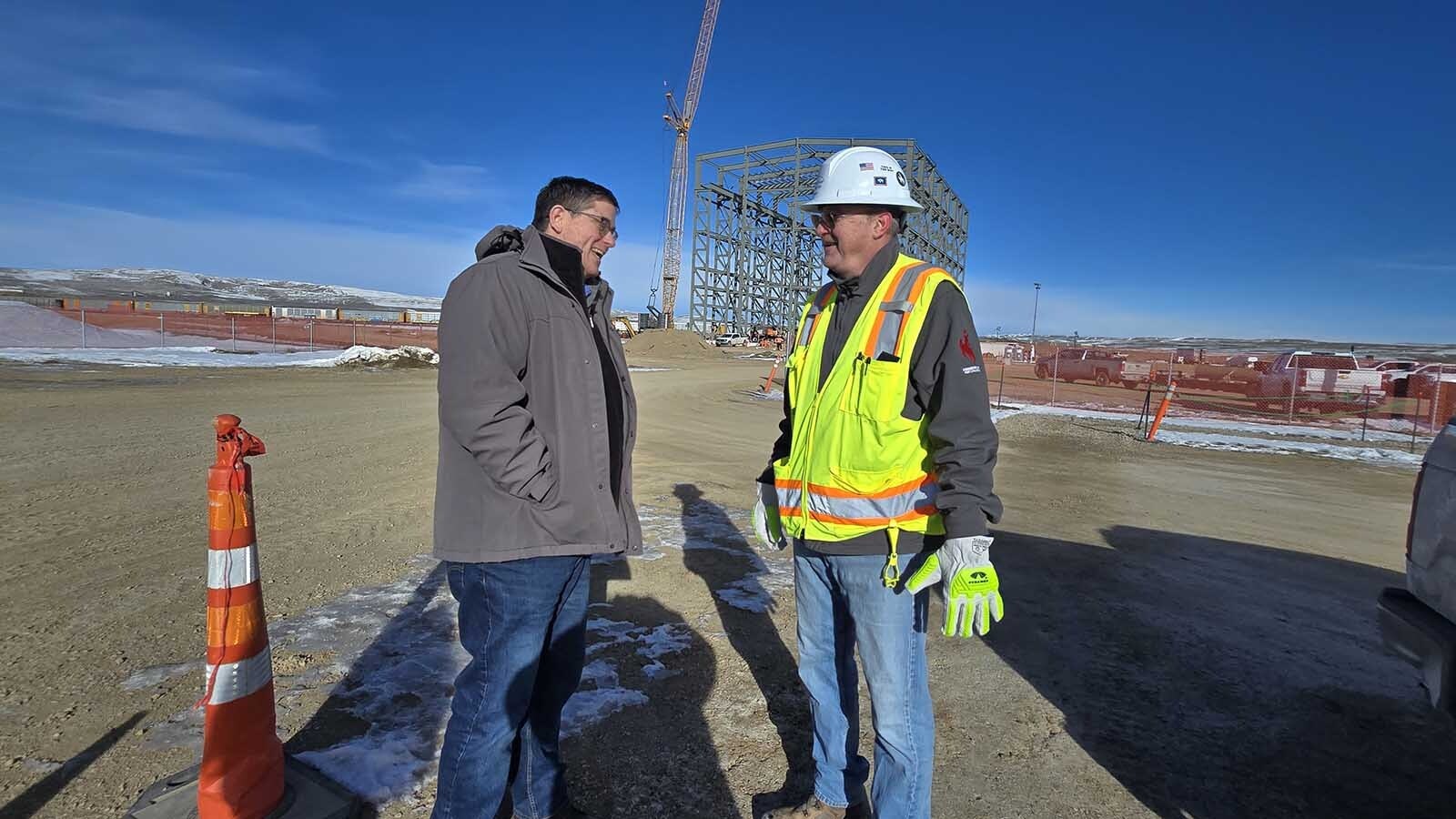 Pat Young, left, and Andy Chrusciel talk about TerraPower's nuclear plant in Kemmerer. Behind them is the Test and Fill Facility that's under construction.