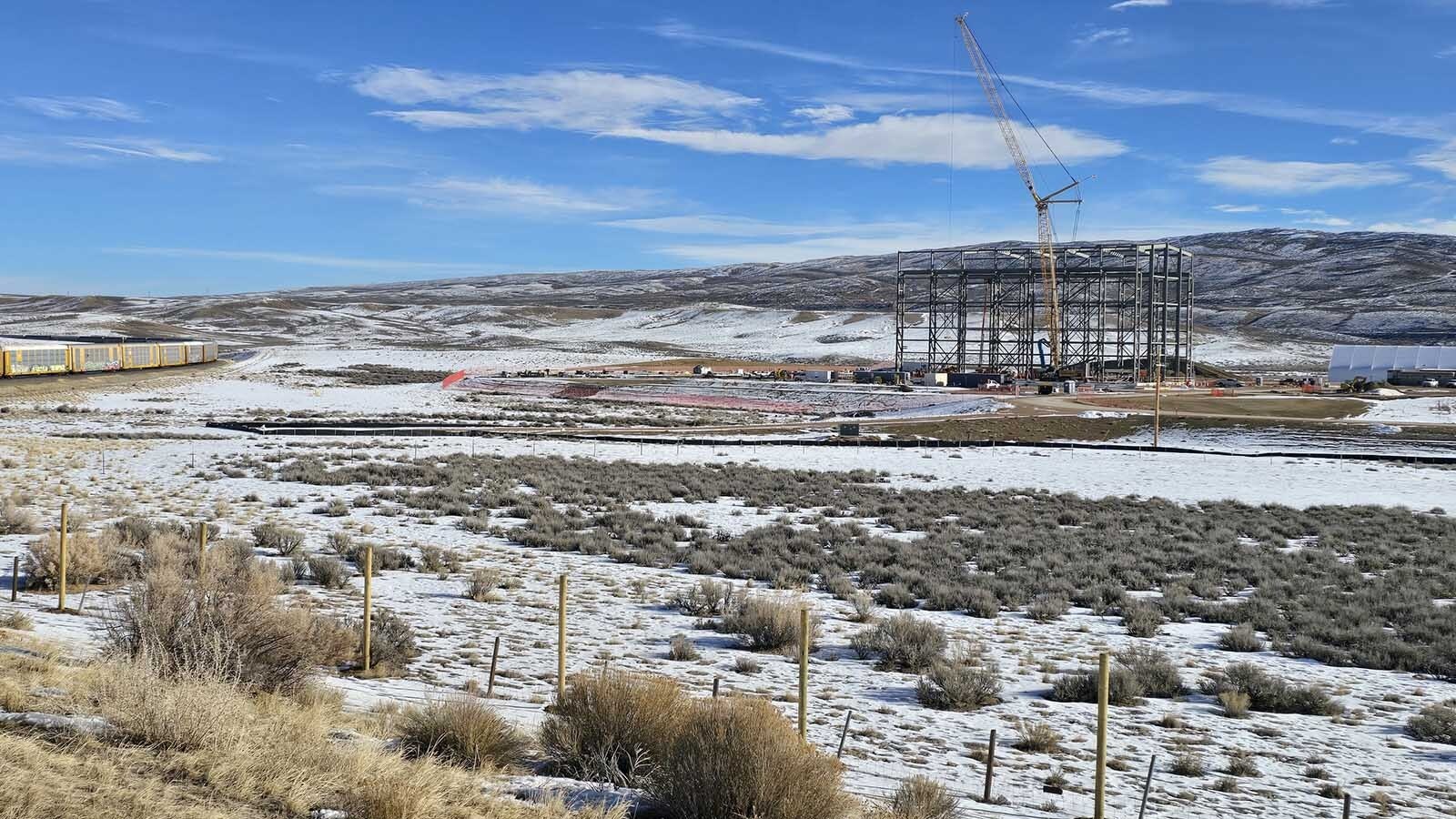 TerraPower's Test and Fill Facility from a distance looks fragile against the snow-covered hills. But it's a massive structure, rising 167 feet in the air with beams that individually weigh as much as 90,000 pounds. The location is near the railroad, and a spur could be built on site relatively easily, but the equipment is too large to deliver that way.