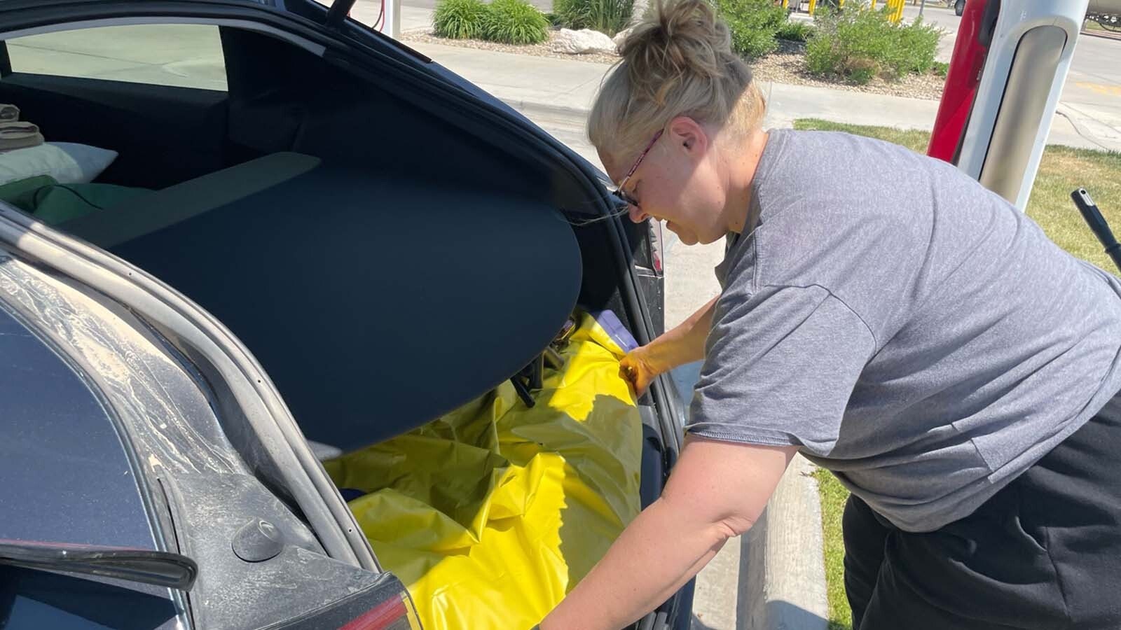 Alison Streeter organizes her road trip gear before hitting the road headed west in her Tesla.