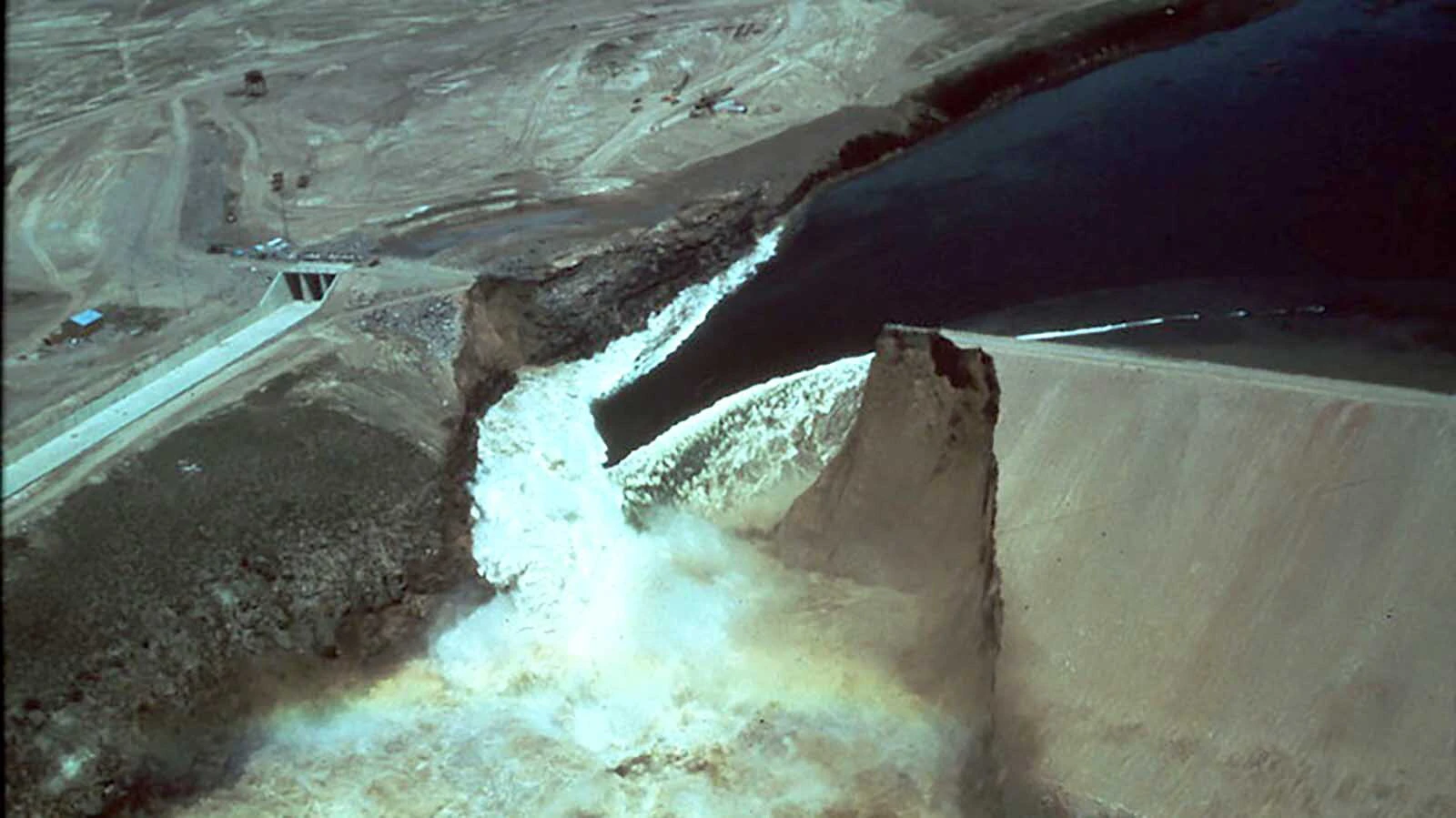 Photos taken at the time of the Teton Dam disaster show how water started leaking and then waters surging through the dam site.
