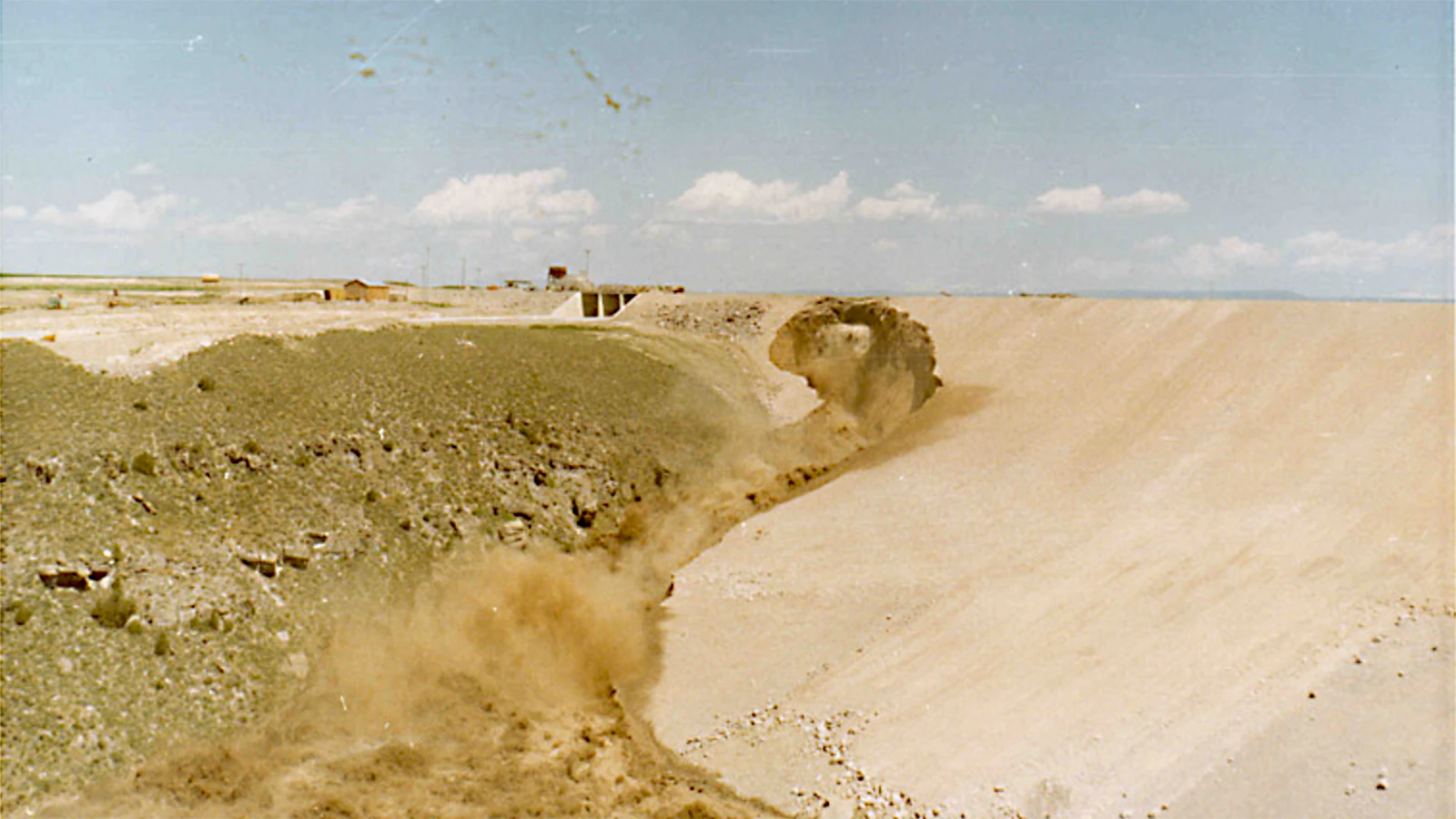 Photos taken at the time of the Teton Dam disaster show how water started leaking and then waters surging through the dam site.