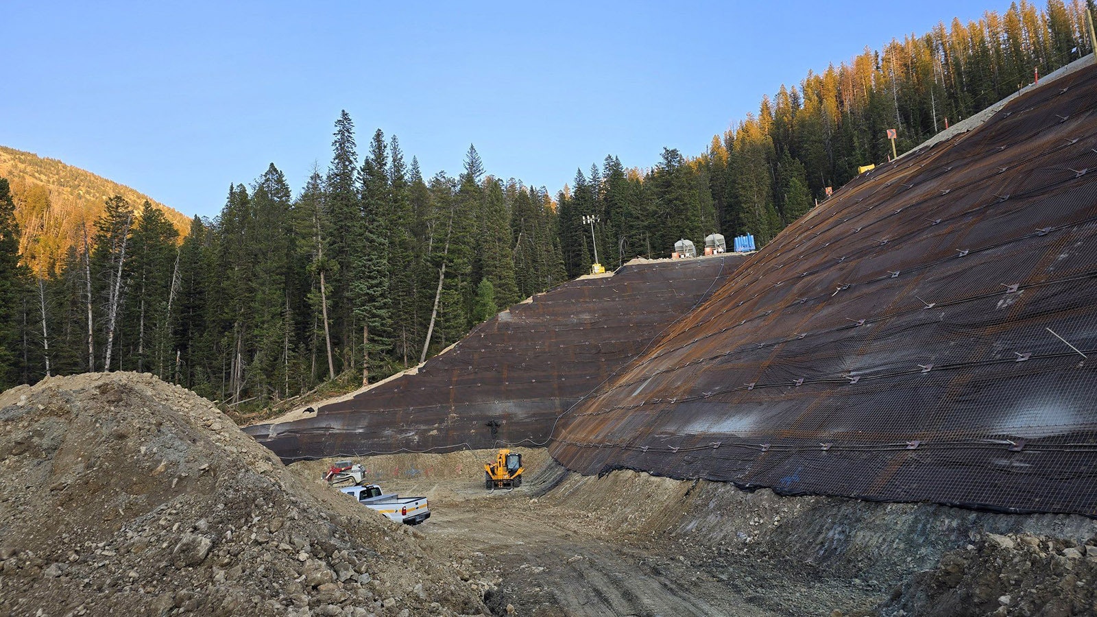 Work continues on building up and reinforcing a section of mountain that fell away in June and took part of Teton Pass with it.