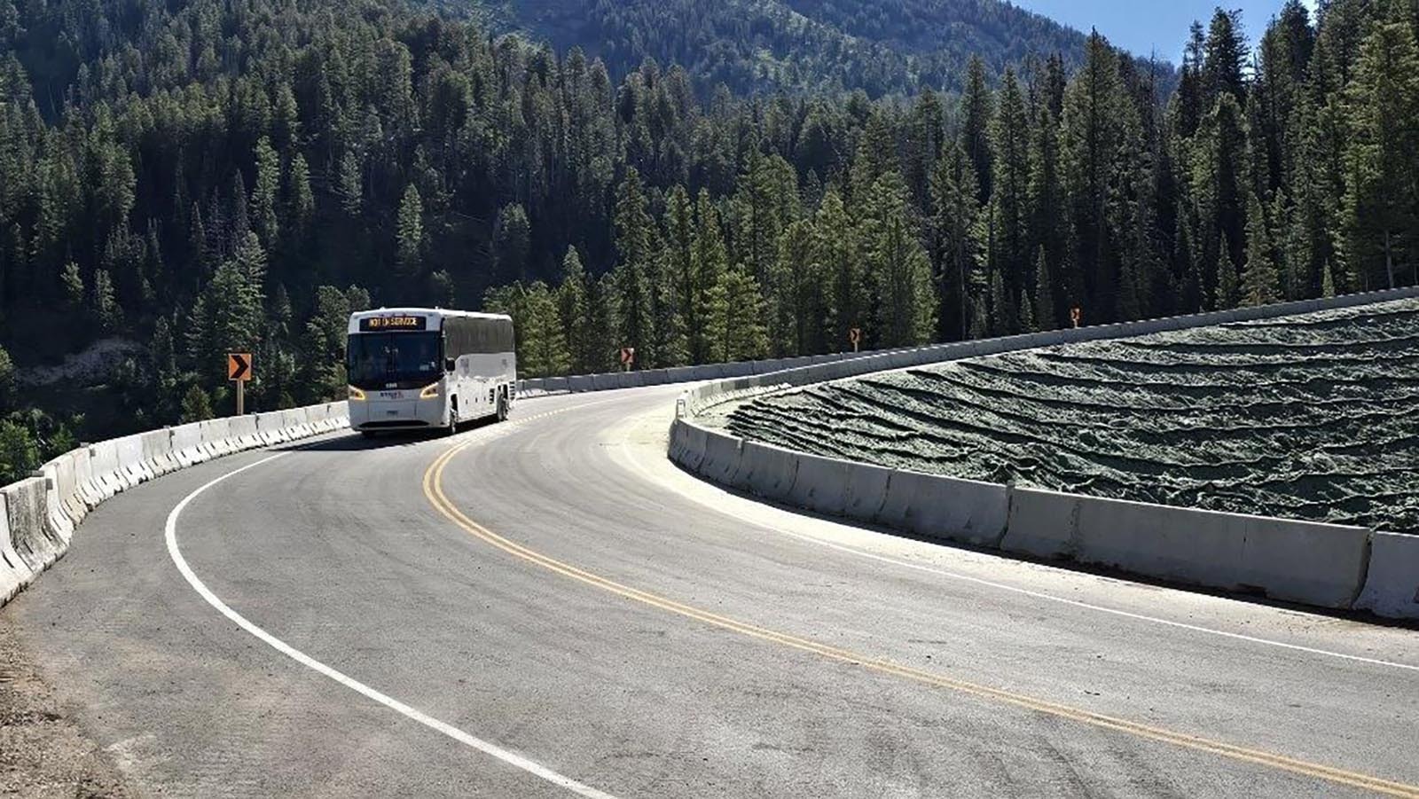 The first vehicle travels over a rebuilt temporary fix for the collapsed section of Teton Pass.