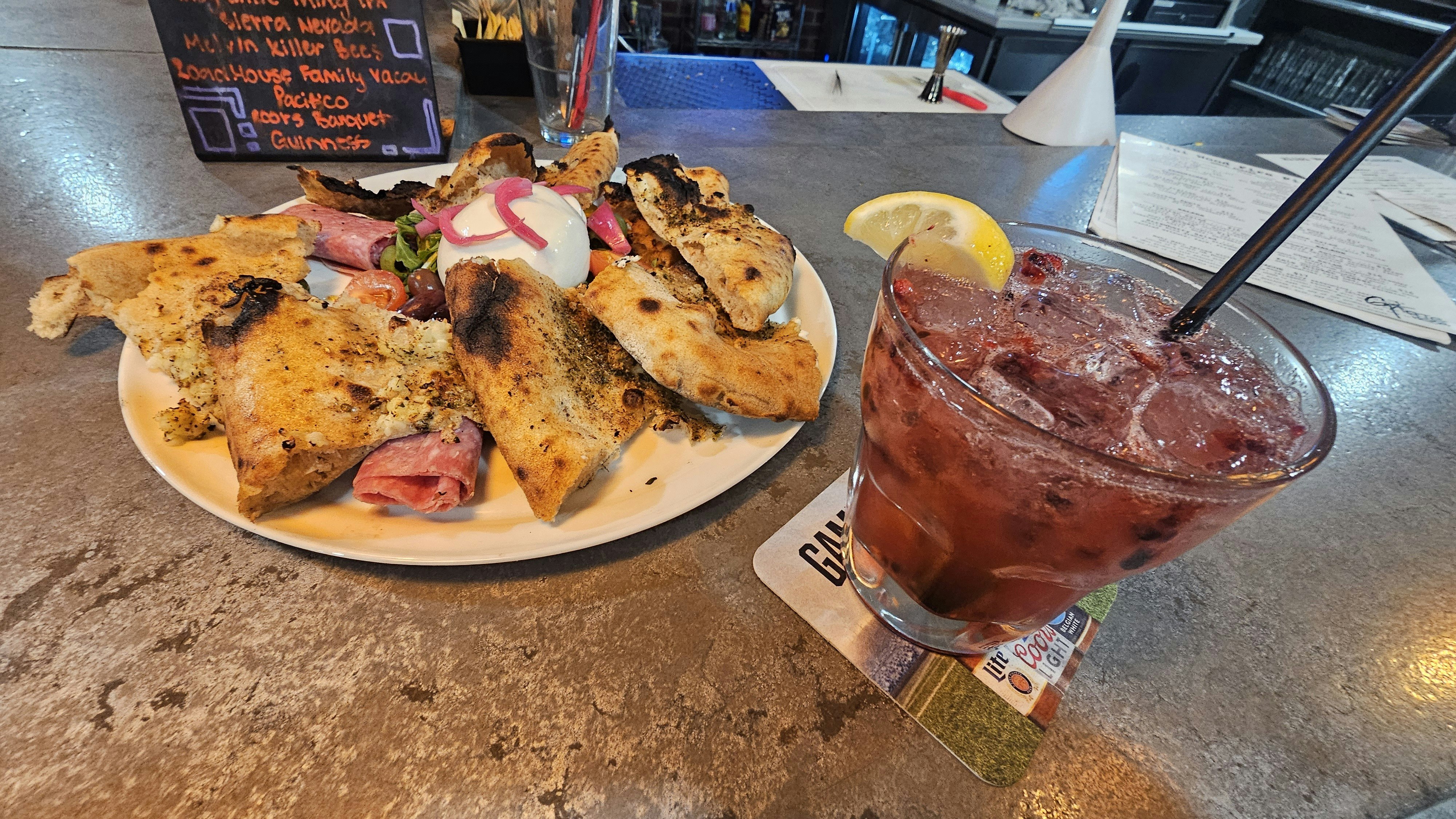 A perfect supper at Alibi Wood Fire Pizzaria — wood fired sourdough with burrata and charcuterie and a cocktail called Pure Joy. Guaranteed to put a smile on any human's face.